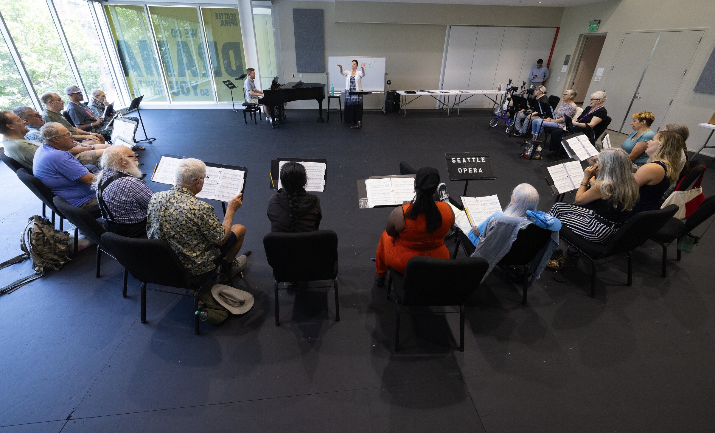 Members of the veterans choir rehearse in Seattle on Aug. 6. In the center background, Micaela Calzaretta of Seattle Opera and the Path with Art veterans choir conducts. (Ken Lambert / The Seattle Times)