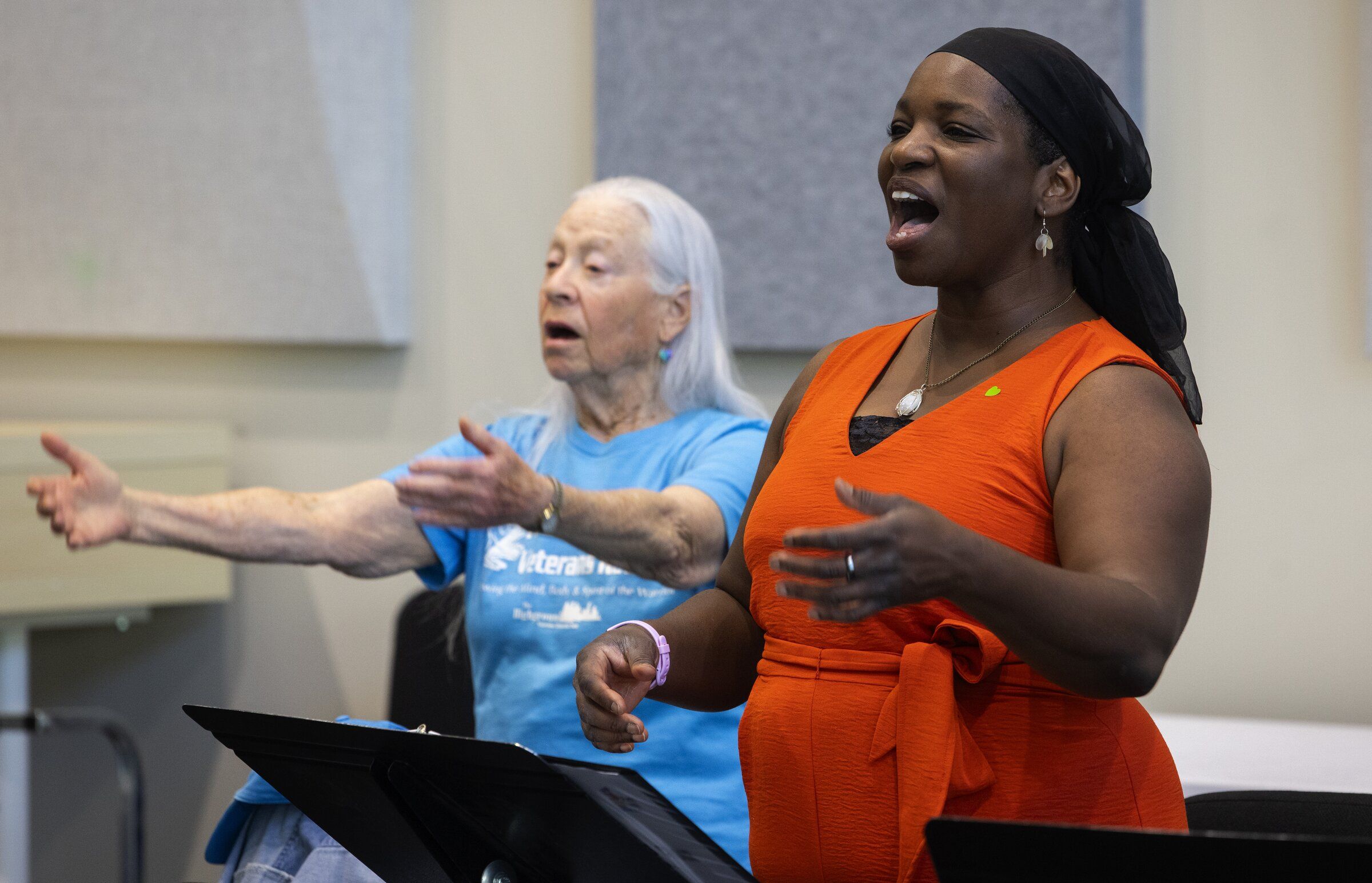 Shända De Anda, right, a U.S. Air Force combat veteran, and Sarah Blum, who served as a combat U.S. Army nurse in Vietnam, rehearse on Aug. 6 in Seattle with a veterans choir formed from a partnership between Path with Art and Seattle Opera. Path with Art is one of the organizations working with the Washington State Arts Commission on a pilot program exploring social prescribing. (Ken Lambert / The Seattle Times)