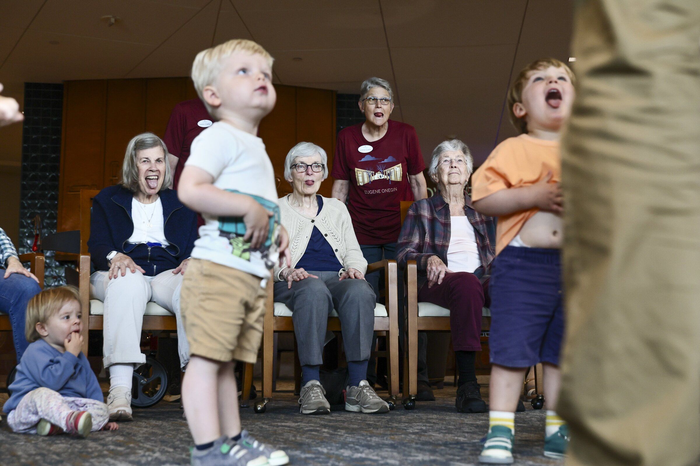Chris Cady, standing, and, seated from left, Betty McCoy, Judy Peterson and Florence Peterschmidt “get the wiggles out” with children in Bayview’s Intergenerational Children’s Center this month in Seattle. (Kevin Clark / The Seattle Times)