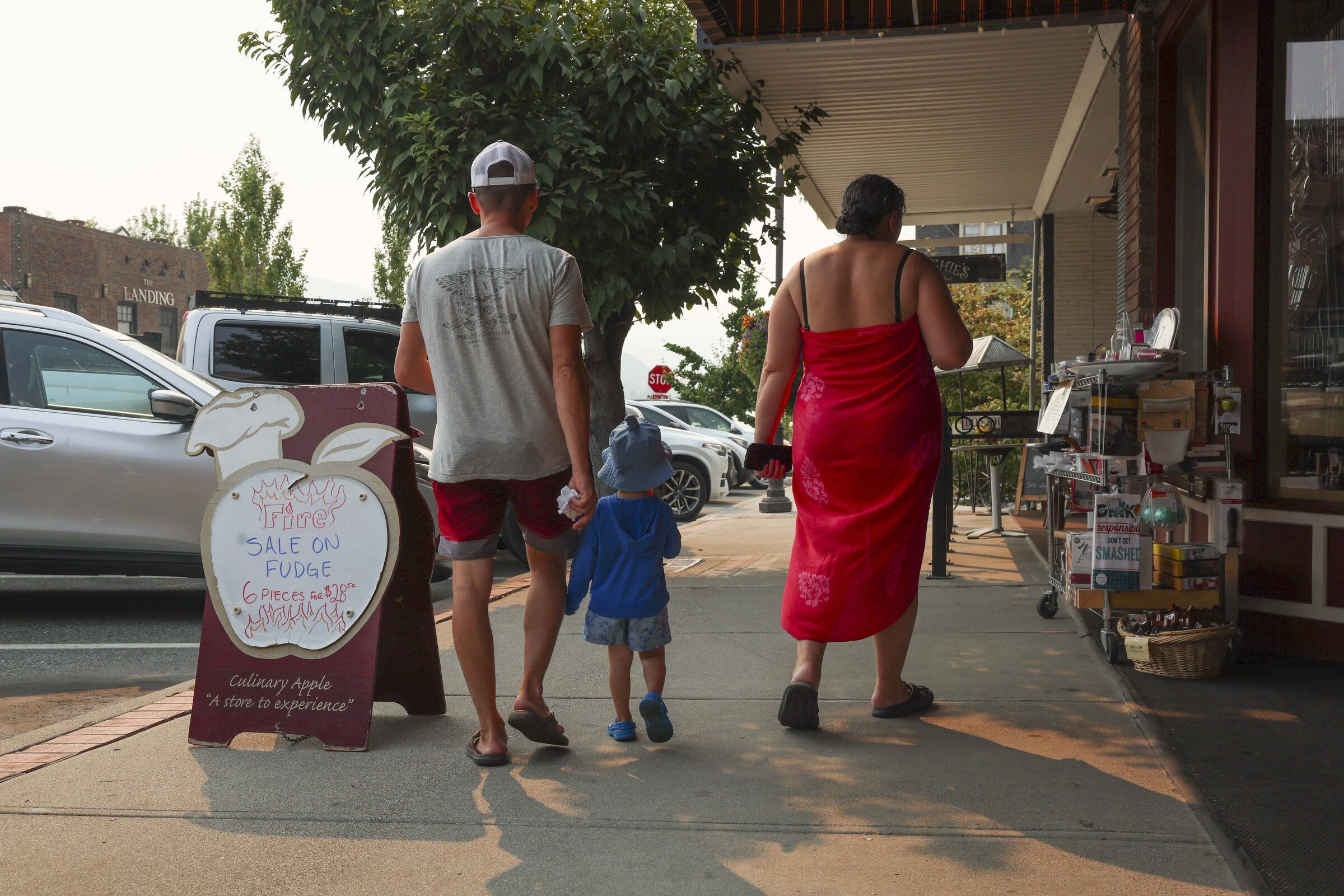 People walk past the Culinary Apple street sign in Chelan on Thursday, Aug. 20. (Ivy Sebayo / The Seattle Times)