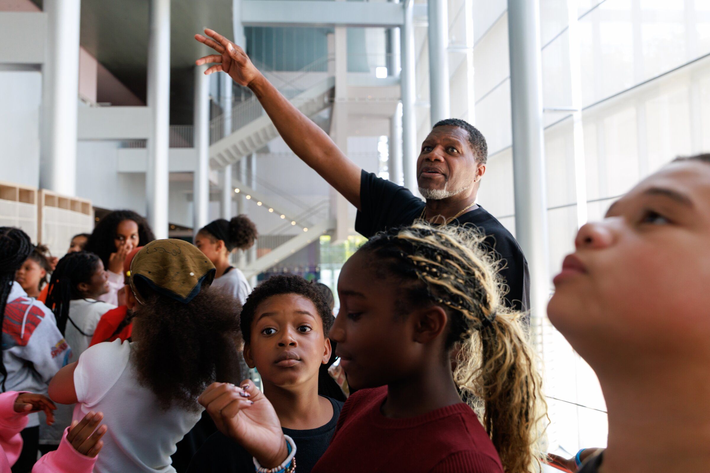 Isaiah Anderson Jr., co-founder and artistic director of Acts On Stage, center, gives students their first tour of the lobby and stage at McCaw Hall, where more than 80 young people will perform in Seattle’s youth summer musical “Peter Pan: Ready to Fly” Aug. 28-30. This year marks the first time the musical will be held at McCaw Hall. Esquire Henderson, right, Jaydin Wheeler and Korieal Scott look around the McCaw Hall lobby. (Erika Schultz / The Seattle Times)