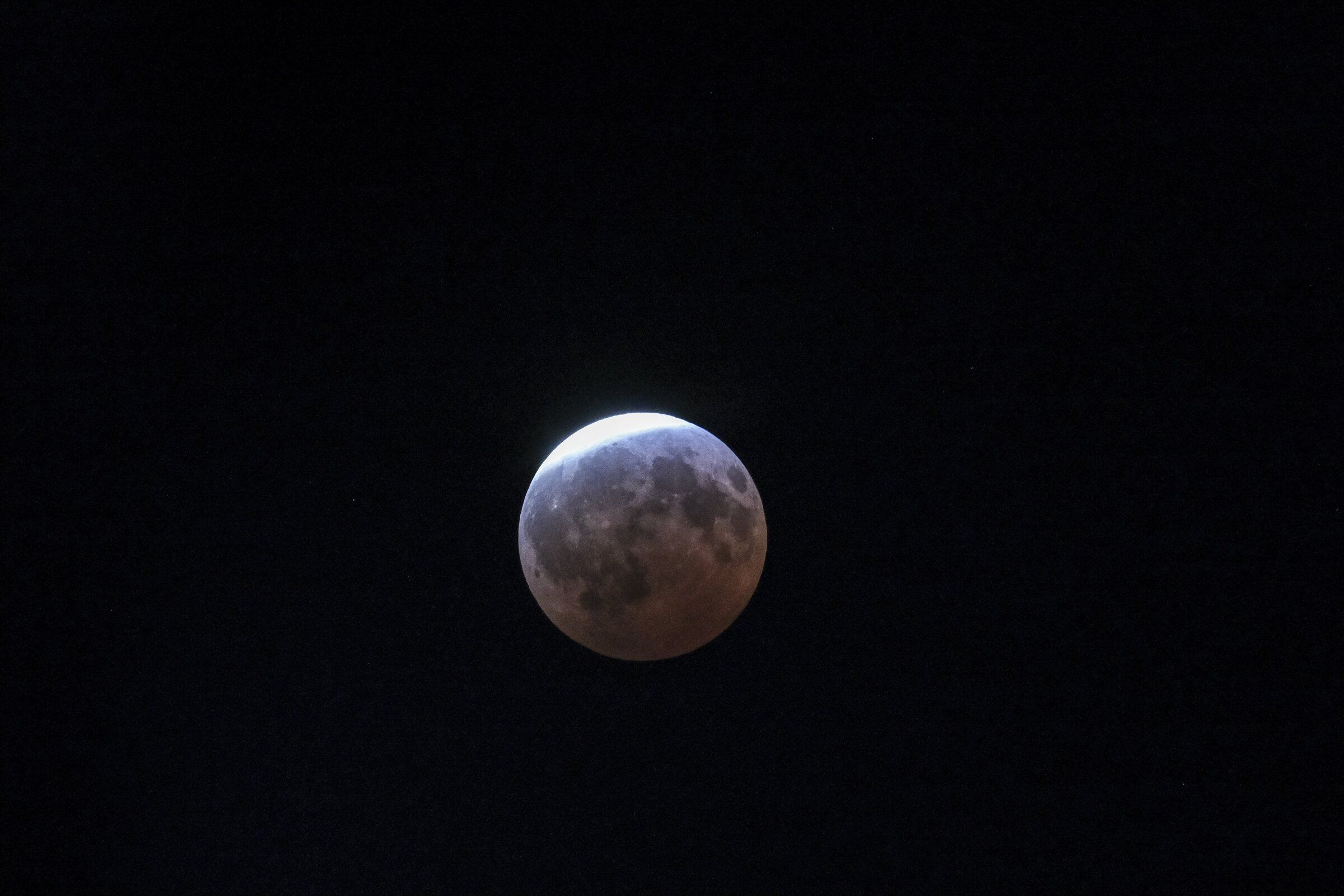 The forecast said the partial lunar eclipse might not be visible because of cloud cover, but many Puget Sound residents were able to witness the celestial event Thursday evening. This photo was taken in Lake Forest Park. (Dean Rutz / The Seattle Times)