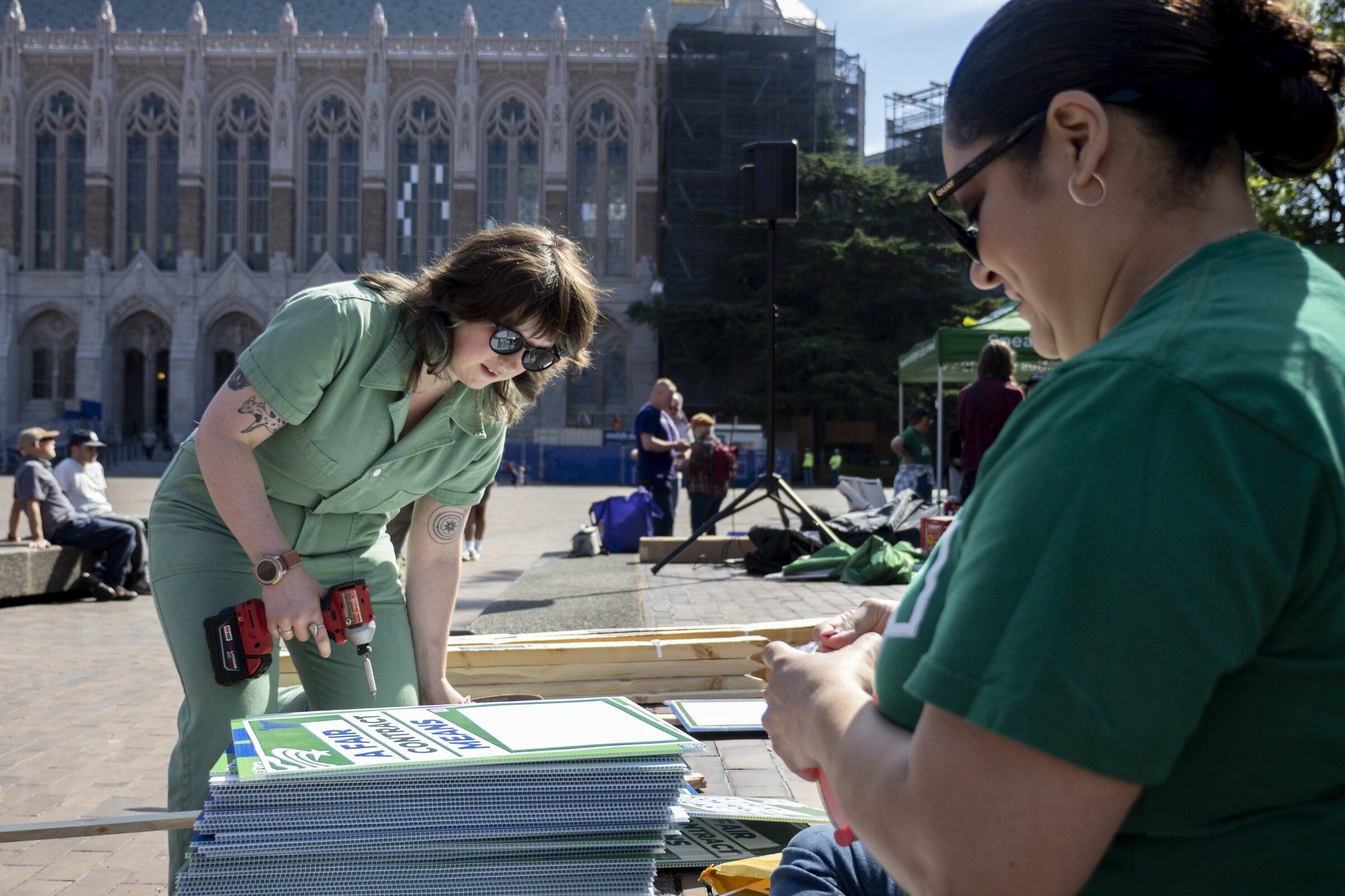 Gillian Fulford, left, and Nikki Gomez prepare union-supporting signs Monday morning on Red Square at the University of Washington. (Kevin Clark / The Seattle Times)