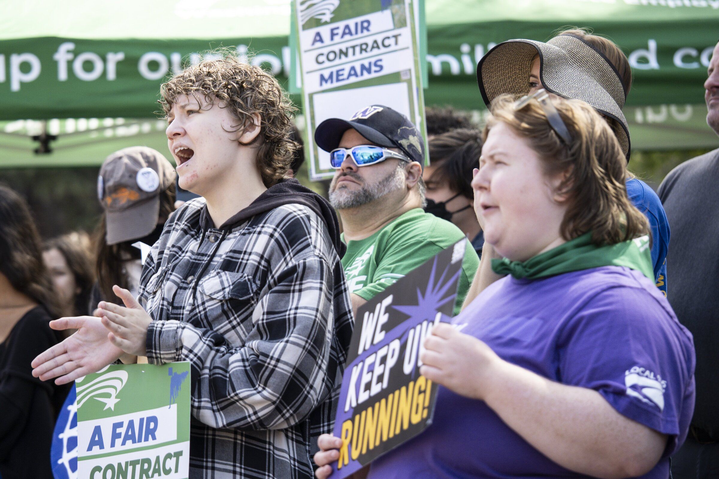 Ari England, left, and Izabella Carpenter, right, rally in support of the Washington Federation of State Employees contract goals Monday morning in Red Square at the University of Washington. (Kevin Clark / The Seattle Times)