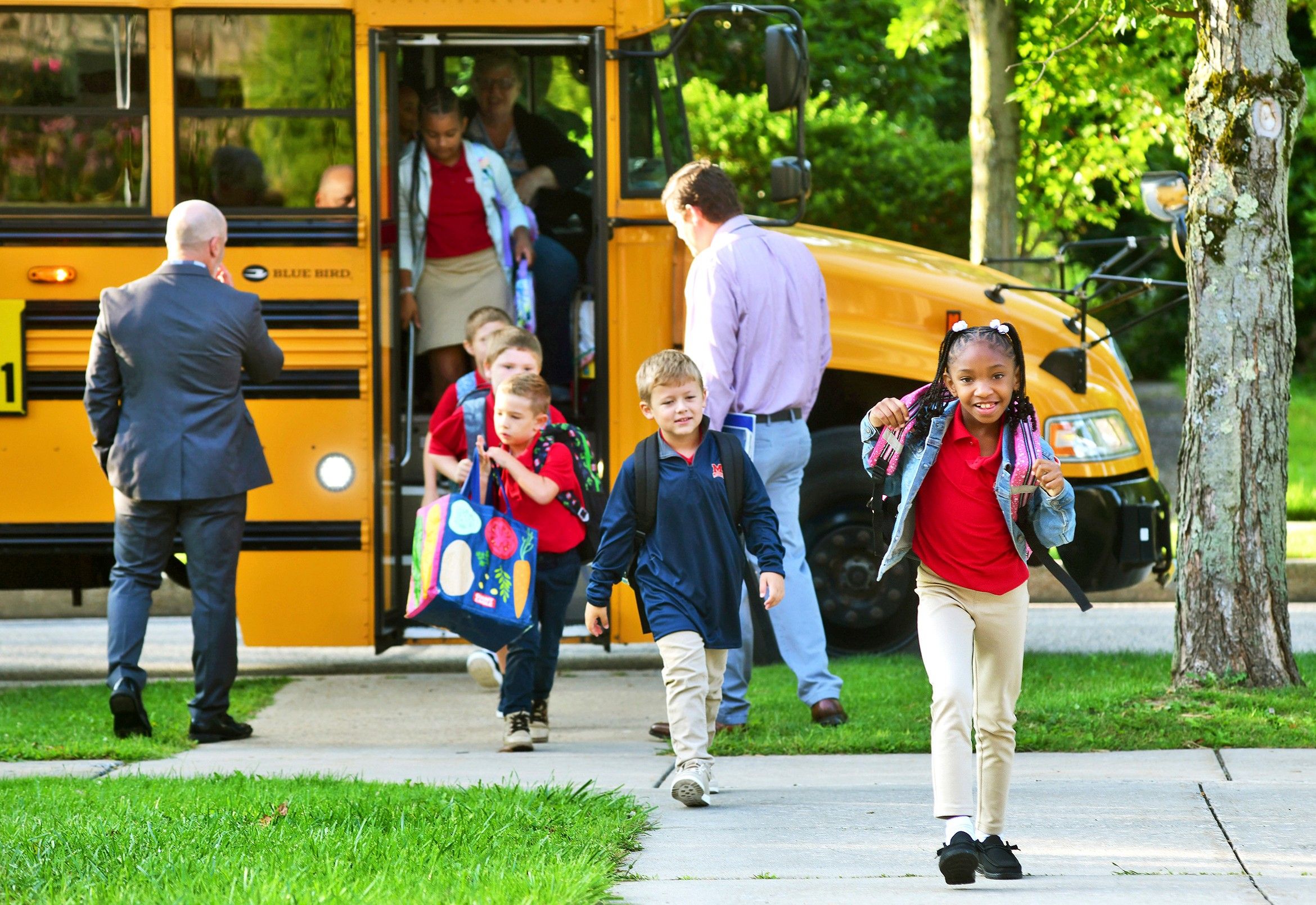 Aaminah Ingram-Kirk, 7, leads the way off the bus for the first day of school at Bishop McCort Catholic Elementary West on Tioga Street in Johnstown, Pa., in 2024. (Thomas Slusser/The Tribune-Democrat via AP, file)