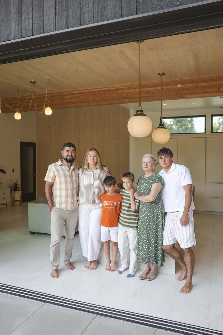 Abdurrahman Hussain, Susan Farzaliyeva and family appear to be enveloped in the warm-colored wood of their mass timber home in Kenmore. With the couple in the living room/kitchen area are sons Imran Hussain, 6; Yusuf Hussain, 9; and Ibrahim Hussain, 16; and Susan’s mother, Lyubov Farzaliyeva. (Ivy Ceballo / The Seattle Times)

 233882 (Ivy Ceballo / The Seattle Times)