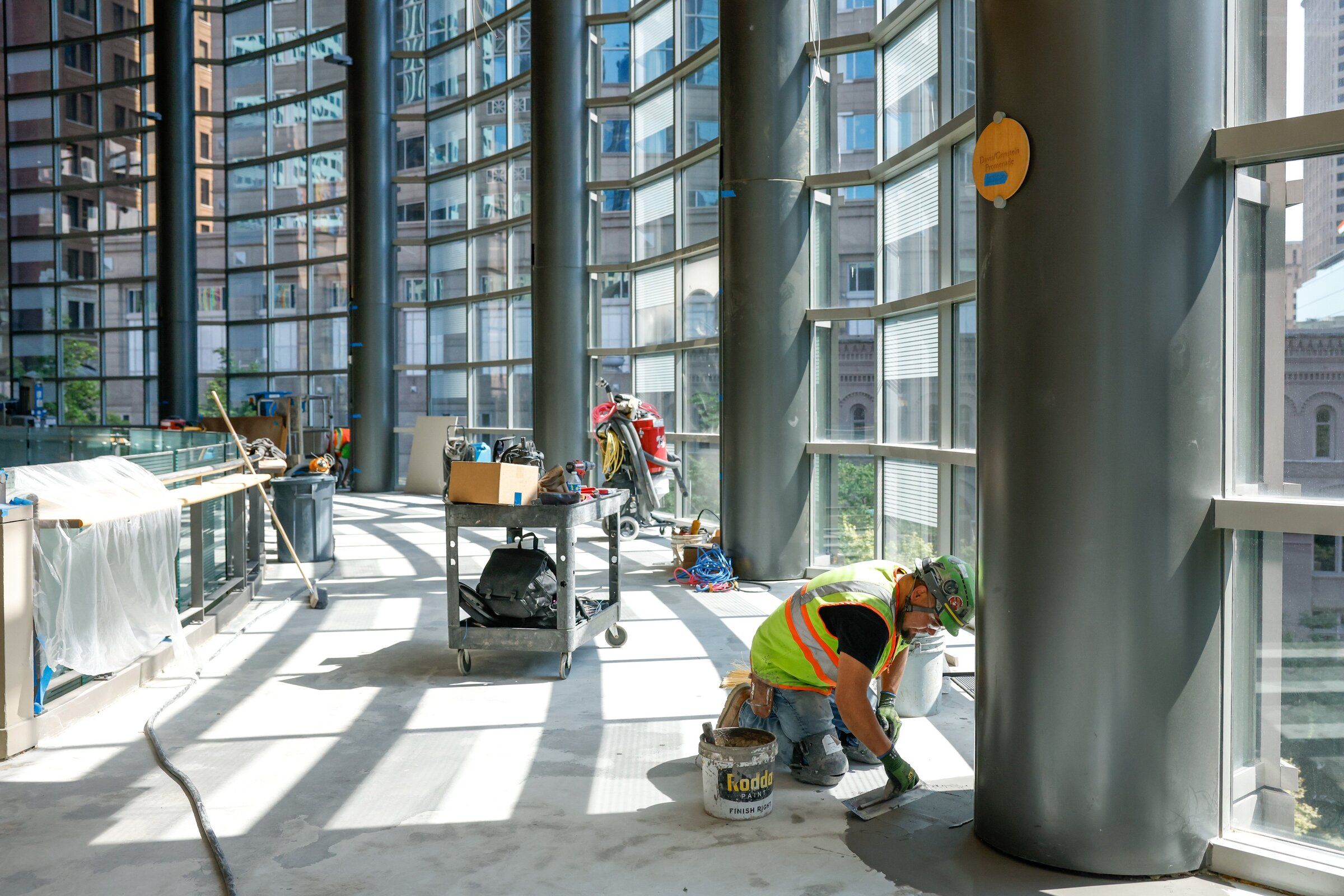 Jamie Villa finishes leveling the floor around a column last month on the Davis/Grinstein Promenade at the Safeco Founders level of Benaroya Hall as part of the building’s $20 million renovation. (Andrew Burk-Stevenson / The Seattle Times)