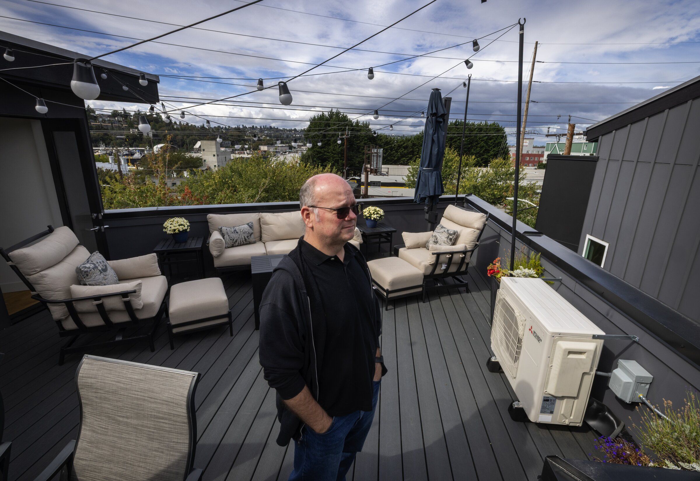 Christopher Vale stands on the rooftop terrace of a Fremont townhouse that he and his wife have been unable to sell. They had to reduce the price by $40,000 from what they paid a year ago. (Ken Lambert / The Seattle Times)
