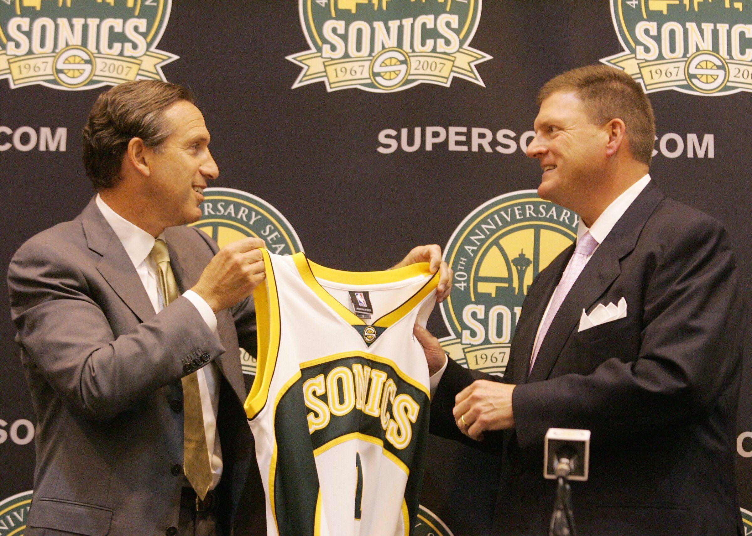 New Sonics owner Clay Bennett, right, receives a jersey from former owner Howard Schultz at the conclusion of the press conference. (Ken Lambert / The Seattle Times)