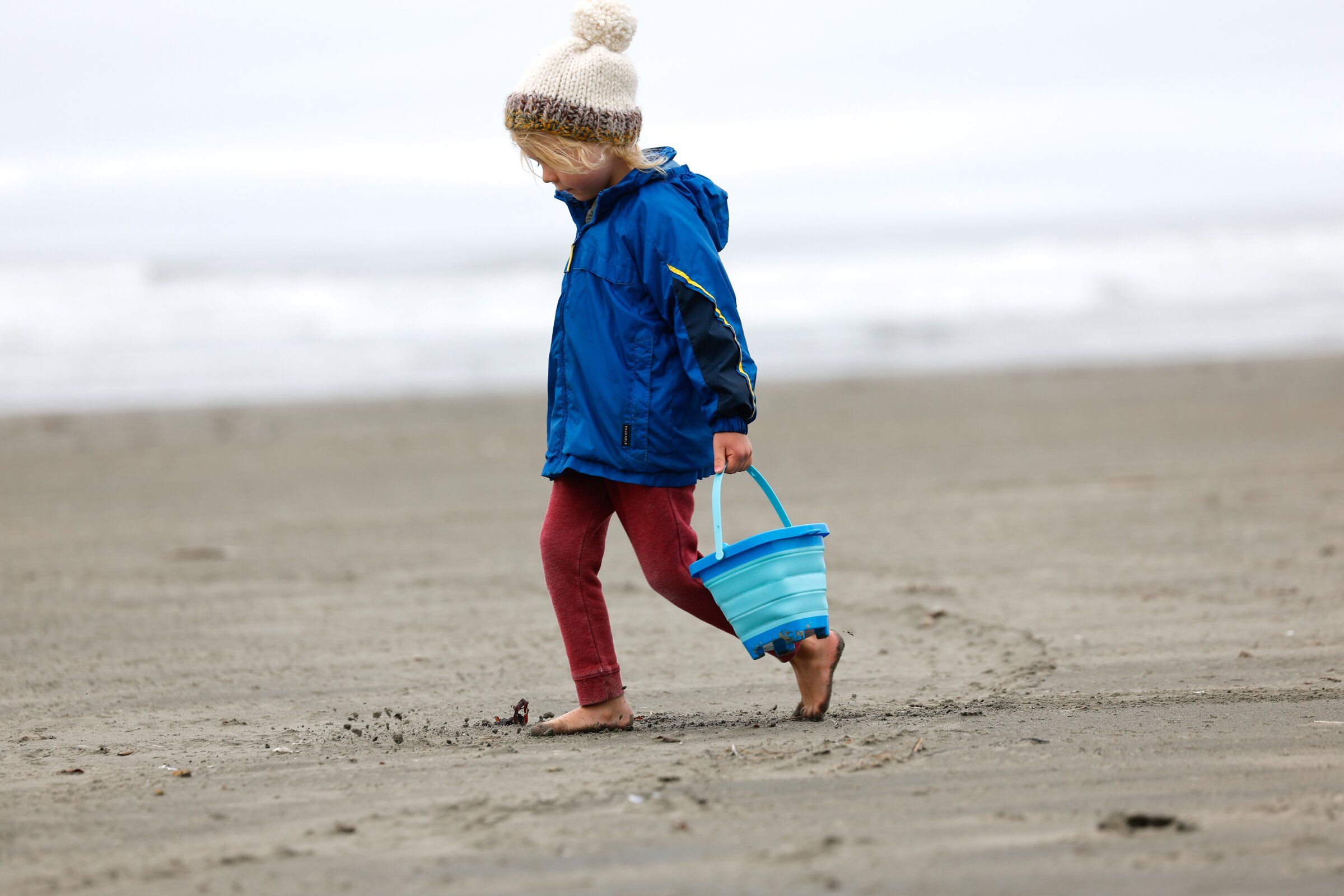 Phineas Bowman feels the sand between his toes at Mocrocks Beach in Grays Harbor County in late June. The weather that will once again call for coats and hats is returning. (Karen Ducey / The Seattle Times)