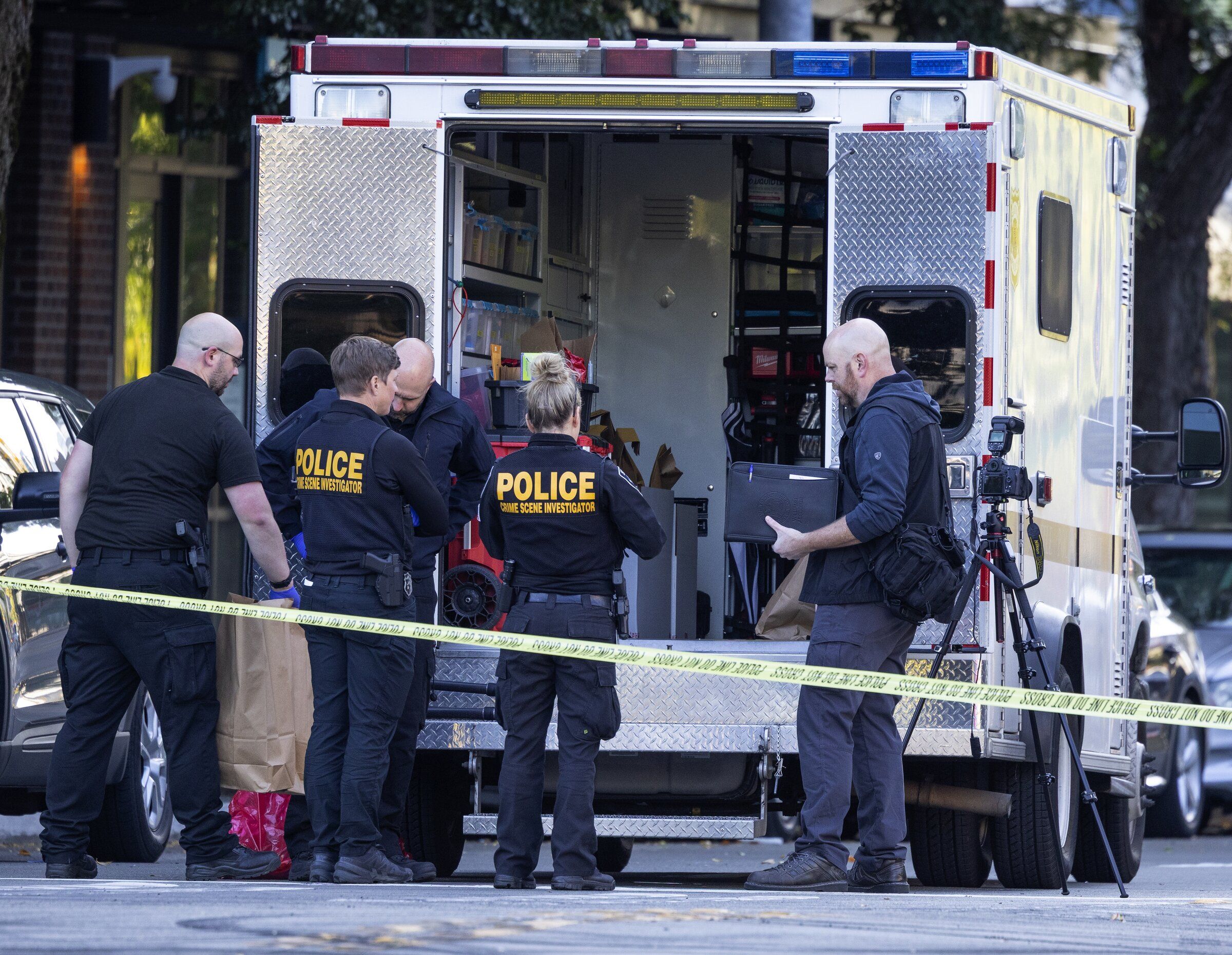 Seattle police investigators stand at a cordoned-off shooting scene at the intersection of Clay Street and Third Avenue in Seattle’s Belltown neighborhood on Sunday. It was one of two fatal overnight shootings in Belltown. (Ken Lambert / The Seattle Times)