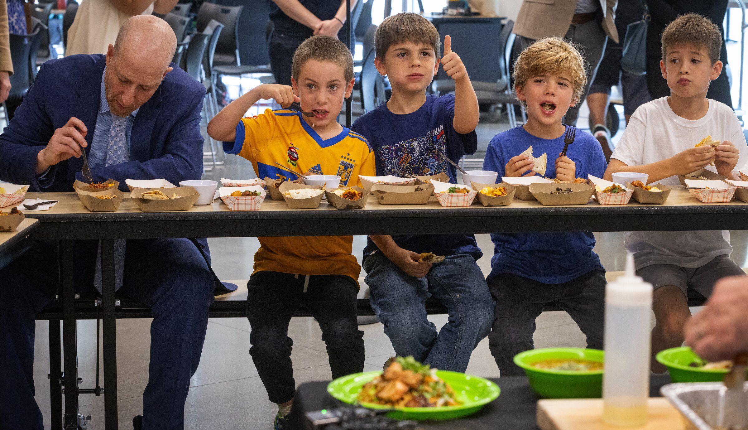 Neil Meyer, a fourth-grade student at Montlake Elementary School, center, gives a thumbs-up to the beef quesadillas as he samples possible new dishes for Seattle schools. On the left is Superintendent Ben Shuldiner, who also took part in Tuesday’s tasting. Students Harry, Cameron and Nolan are also seated at the table. (Ken Lambert / The Seattle Times)