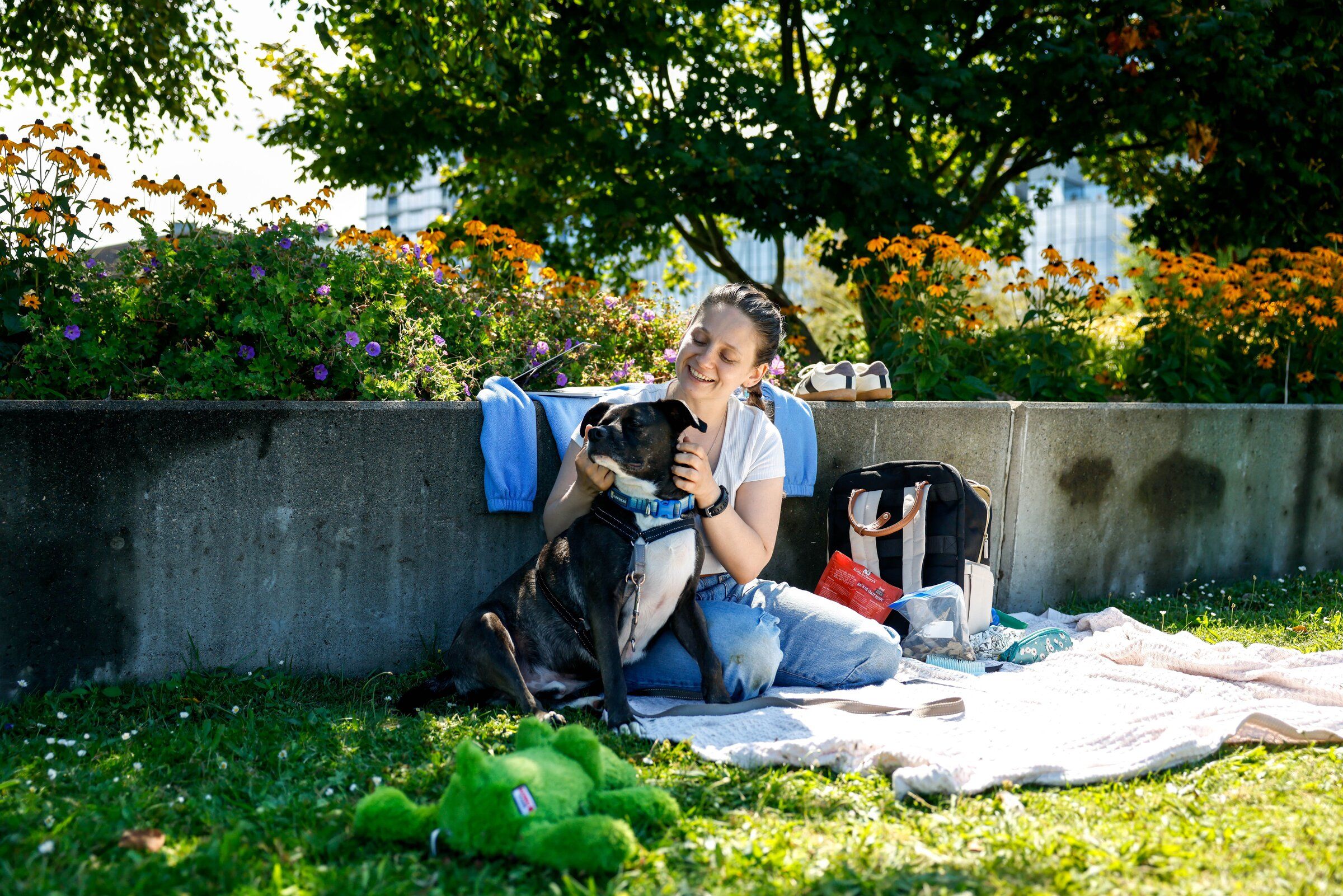 Faith Stacy pets her dog, Toby, at Lake Union Park in Seattle last month. This week will begin with warmer temperatures, sunny skies and not a hint of rain. But a change in the weather is ahead. (Andrew Burke-Stevenson / The Seattle Times)
