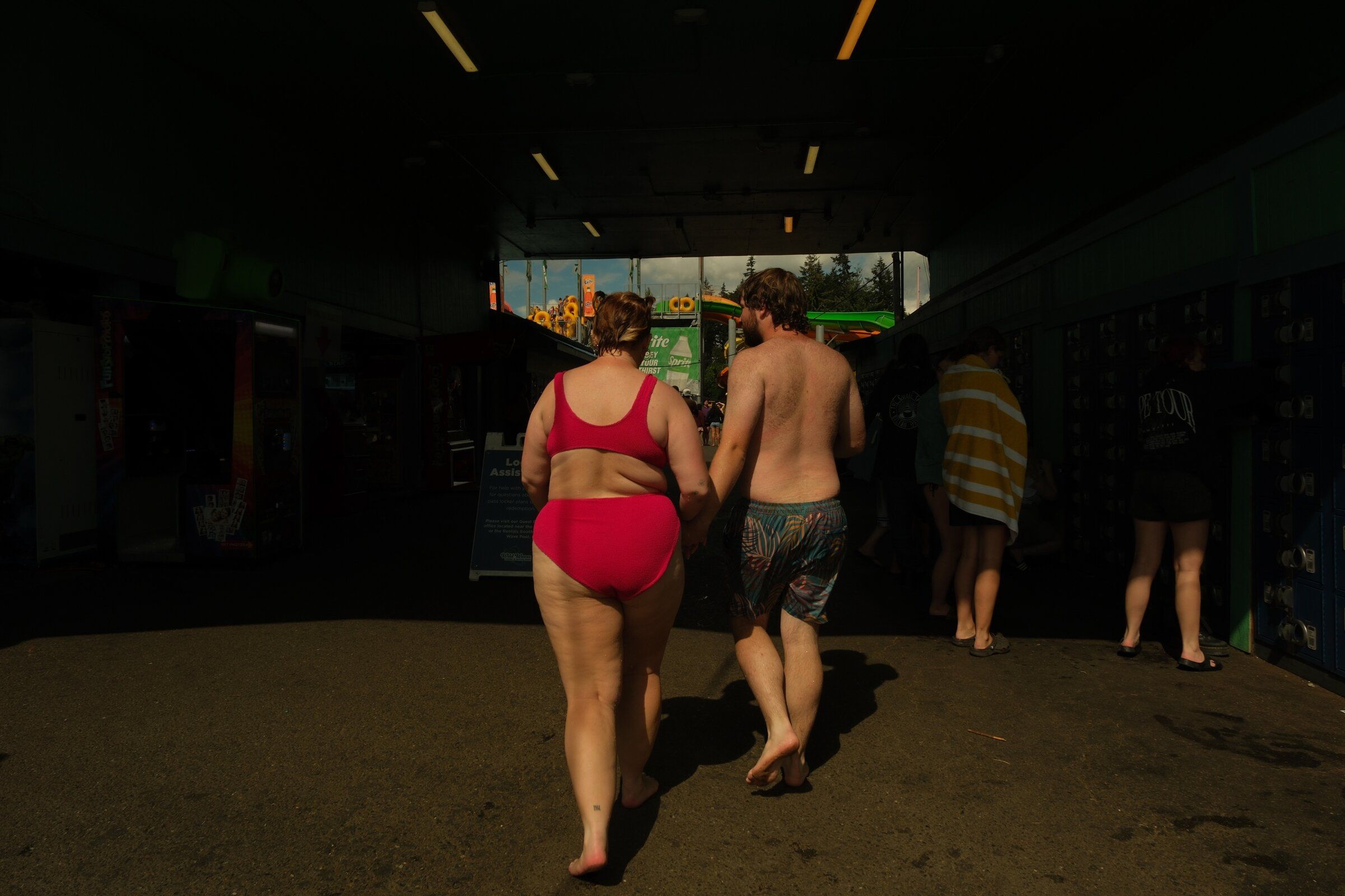 Olivia McCary and Sam Noblich hold hands as they walk through the park on Aug. 29. They said they grew closer through their shared passion for theme parks and are sad that the park is closing. (Genna Martin / special to The Seattle Times)