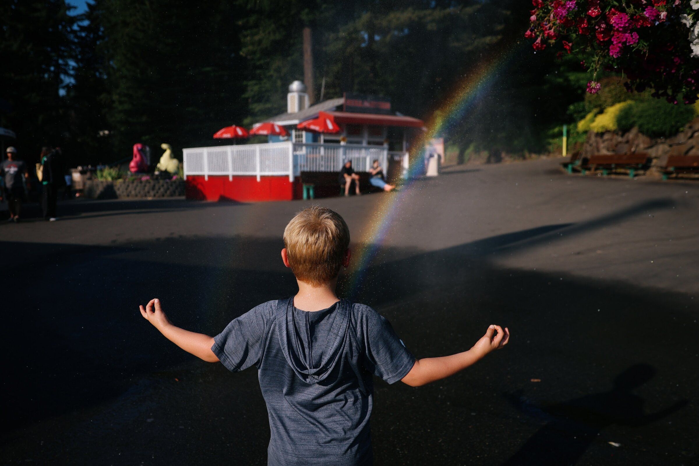 A boy reacts to a rainbow appearing in the mist at Wild Waves on Aug. 18. (Genna Martin / special to The Seattle Times)