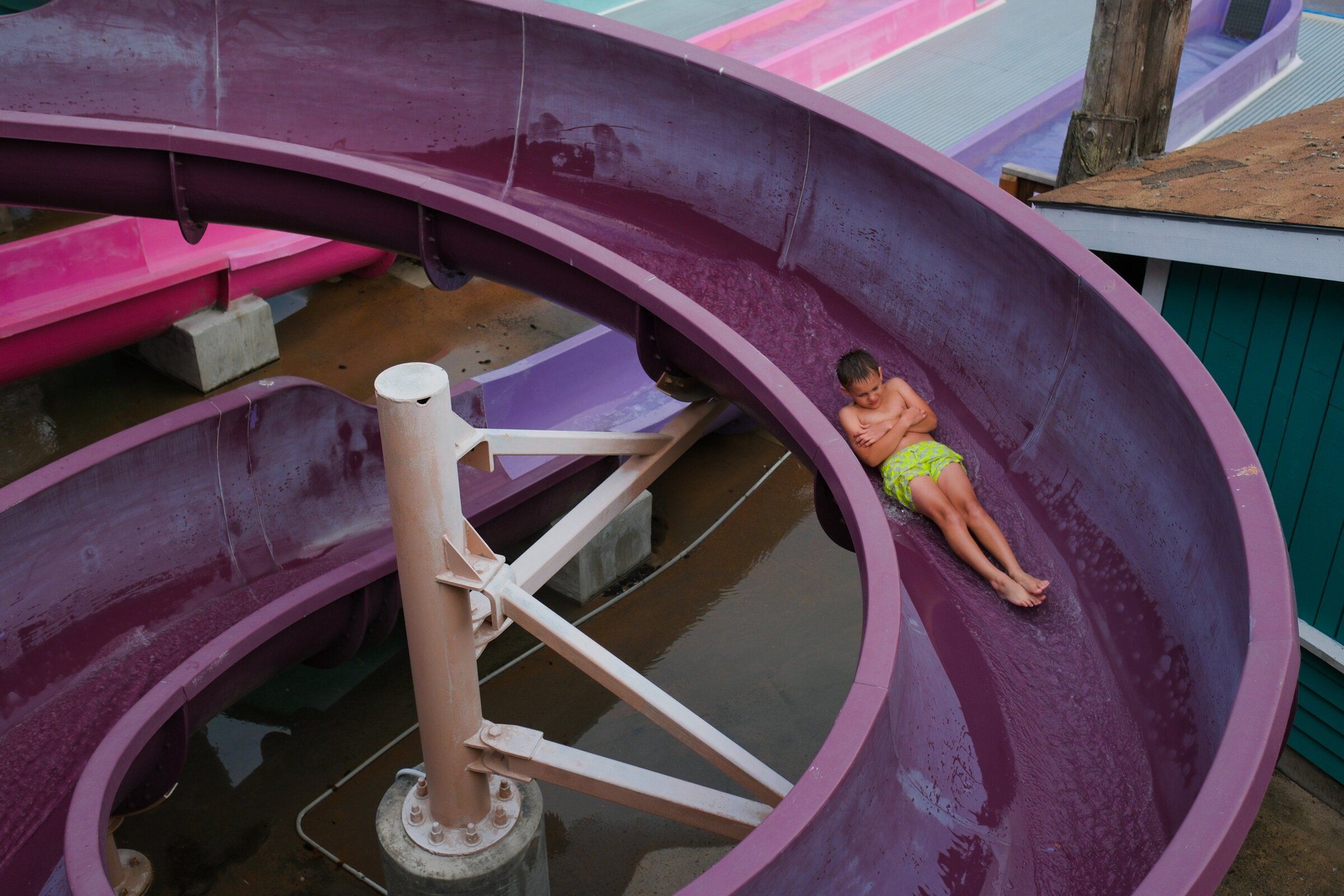 A boy slides sideways into Hooks Lagoon at Wild Waves on Aug. 29. (Genna Martin / special to The Seattle Times)