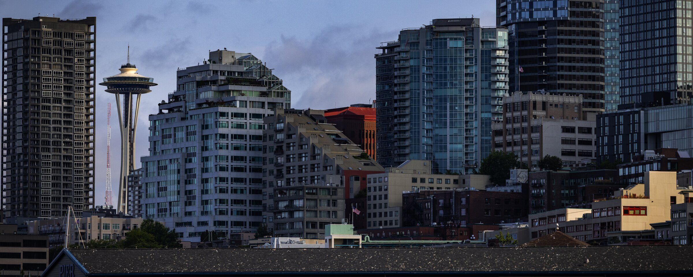 Morning light hits the Space Needle, surrounded by downtown apartments, in August 2025. Facing high interest rates, rising construction costs and other headwinds, developers in Seattle and across much of the country have hit the brakes on new apartment construction. (Ken Lambert / The Seattle Times)