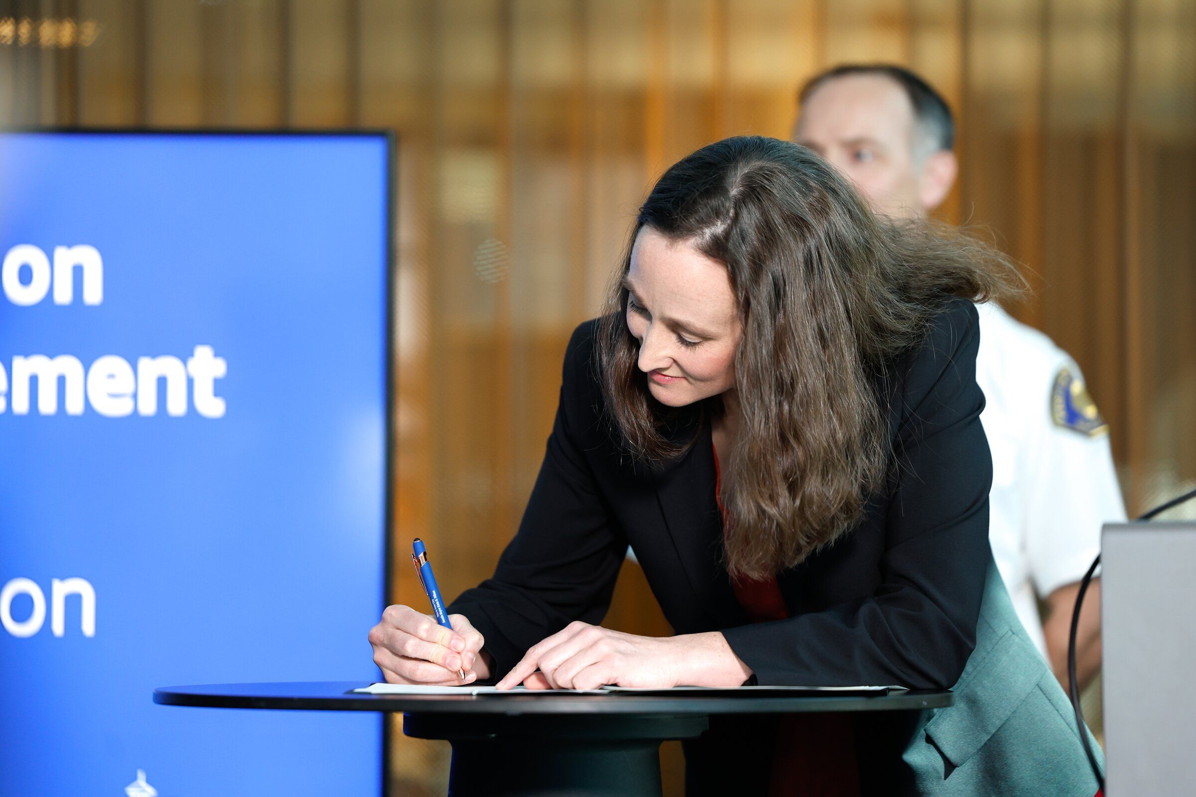 Mayor Katie Wilson signs a new executive order to strengthen Seattle’s approach to emergency preparedness during a news conference on Thursday. (Karen Ducey / The Seattle Times)