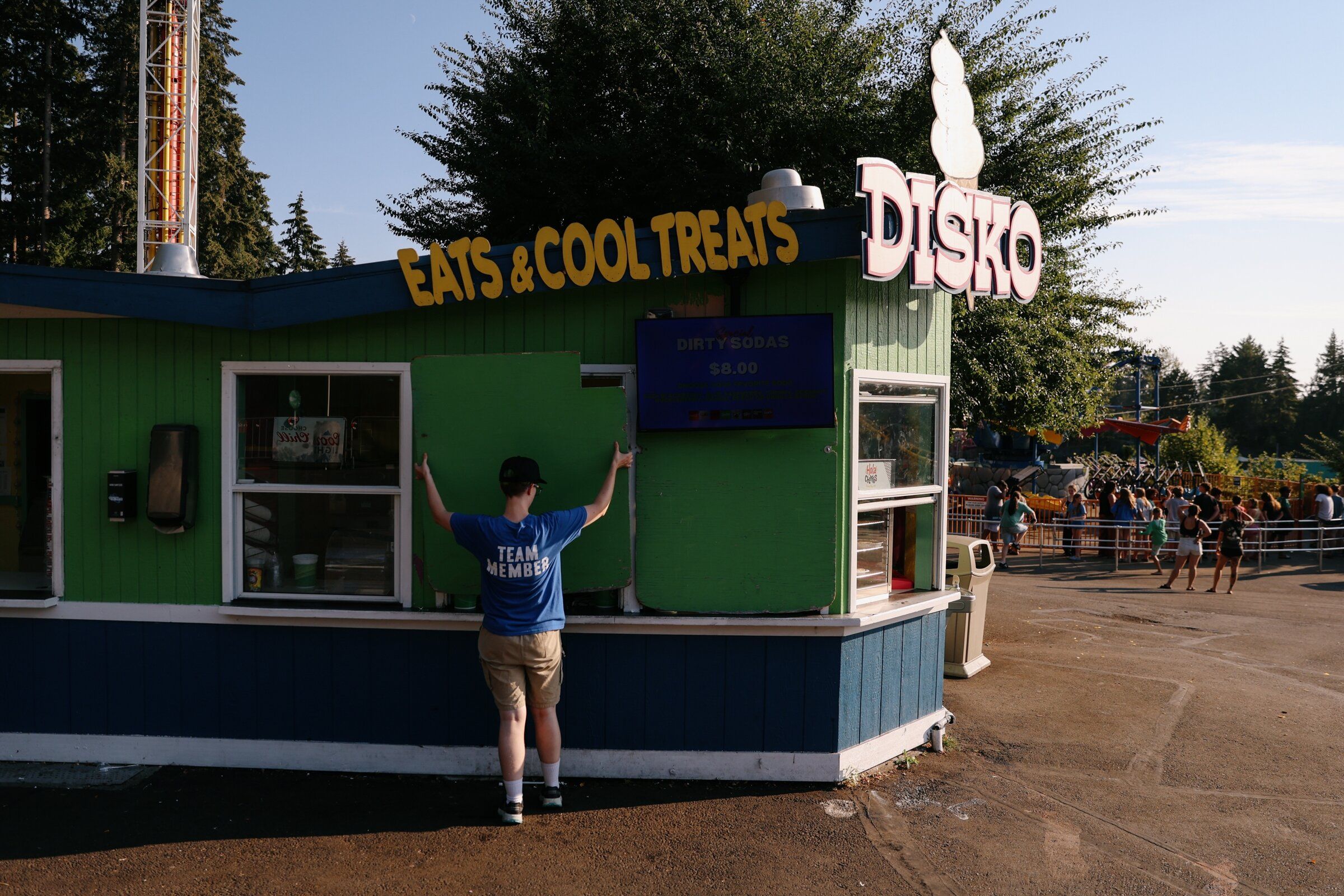 A Wild Waves employee boards up a concession stand at the end of the workday on Aug. 18, 2026. (Genna Martin / special to The Seattle Times)