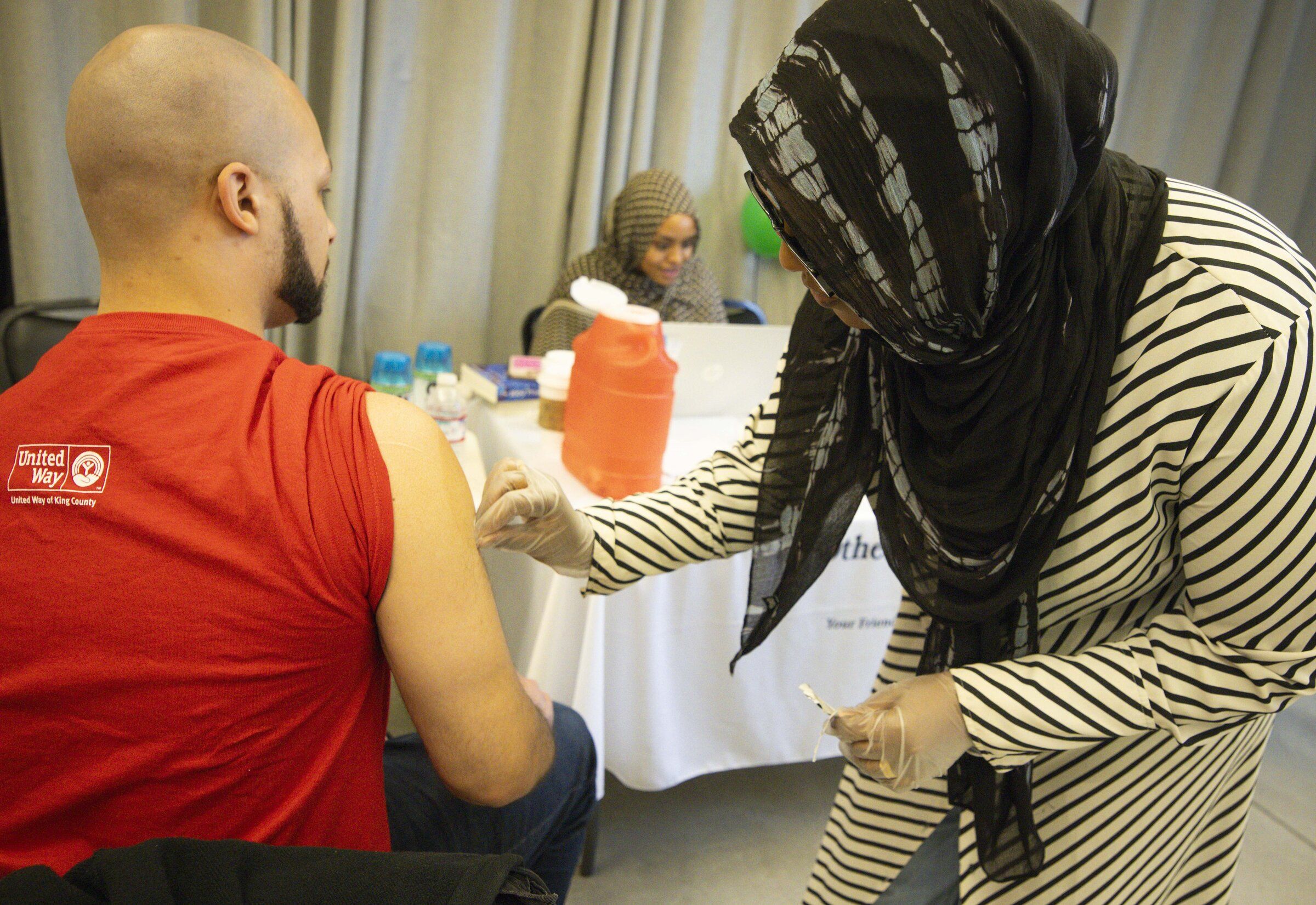 Greg McMurtry Jr. gets ready for a flu vaccine from Ramla Abdi, with Othello Station Pharmacy. This year, a new kind of flu vaccine shown to be superior to traditional ones will be available. (Ivy Ceballo / The Seattle Times, 2025)