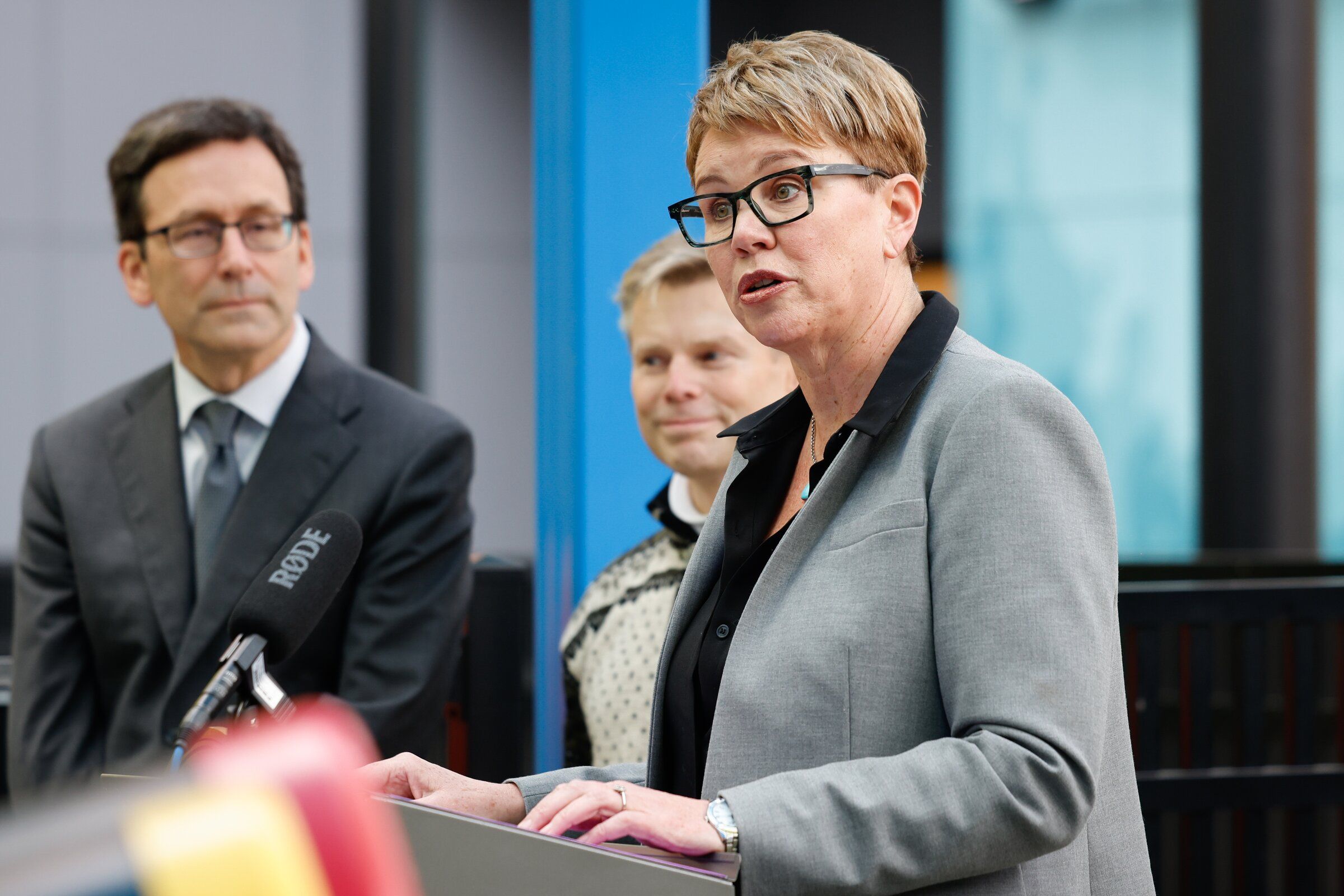Last November, Andi Smith, Executive Director for Washington, the Ballmer Group, right, speaks at a press conference announcing a new grant to expand Washington’s Early Childhood Education and Assistance Program (ECEAP), at the Denise Louie Education Center in Seattle on Wednesday, November 12, 2025. Gov. Bob Ferguson, left, and Sen. Jamie Pedersen, center, are in the background. (Karen Ducey / The Seattle Times, 2025)