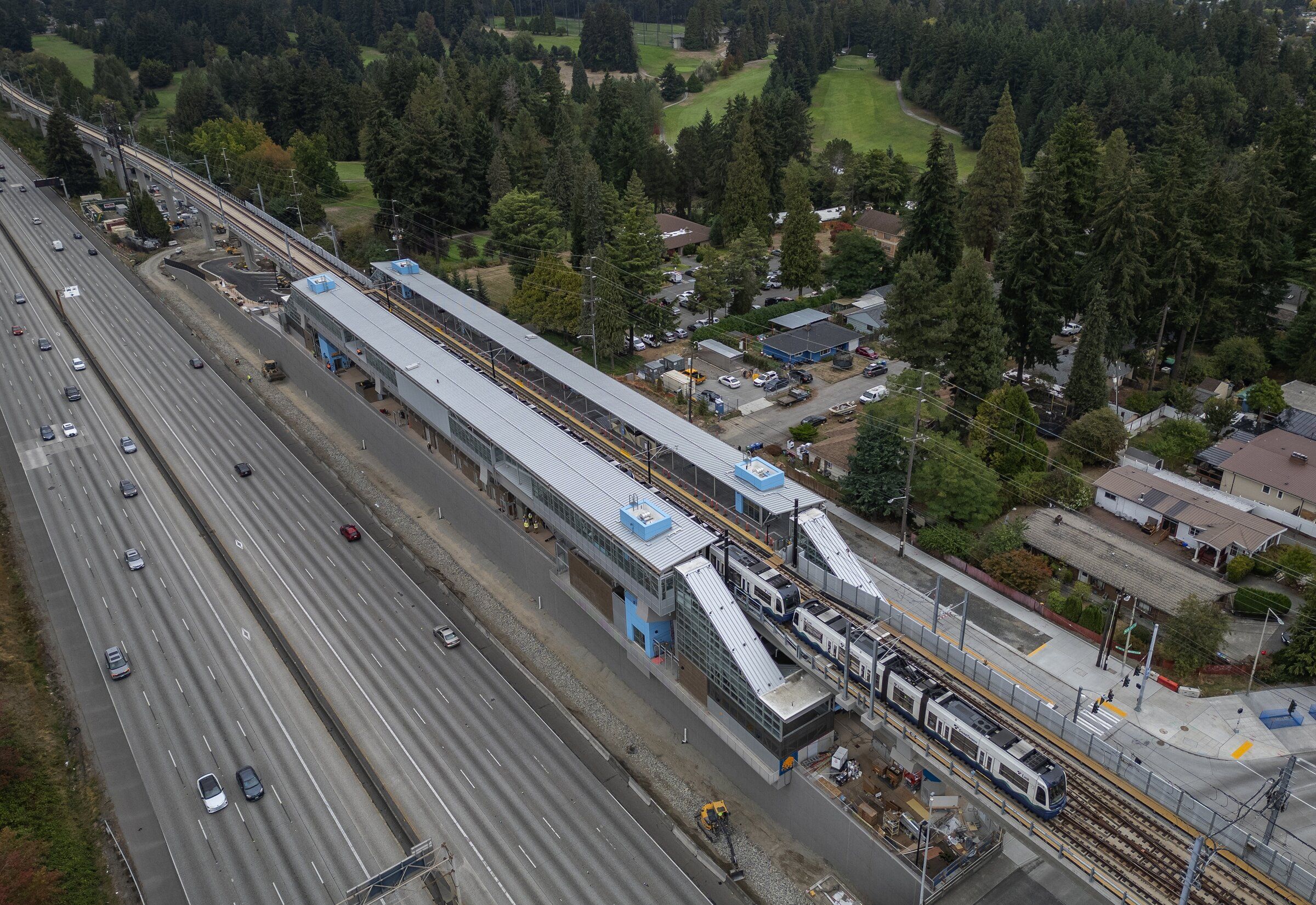 A light rail train heads south through Pinehurst Station, which passengers can begin using Wednesday. In this low-density neighborhood, Jackson Park Golf Course is next to the overhead tracks. (Ken Lambert / The Seattle Times)
