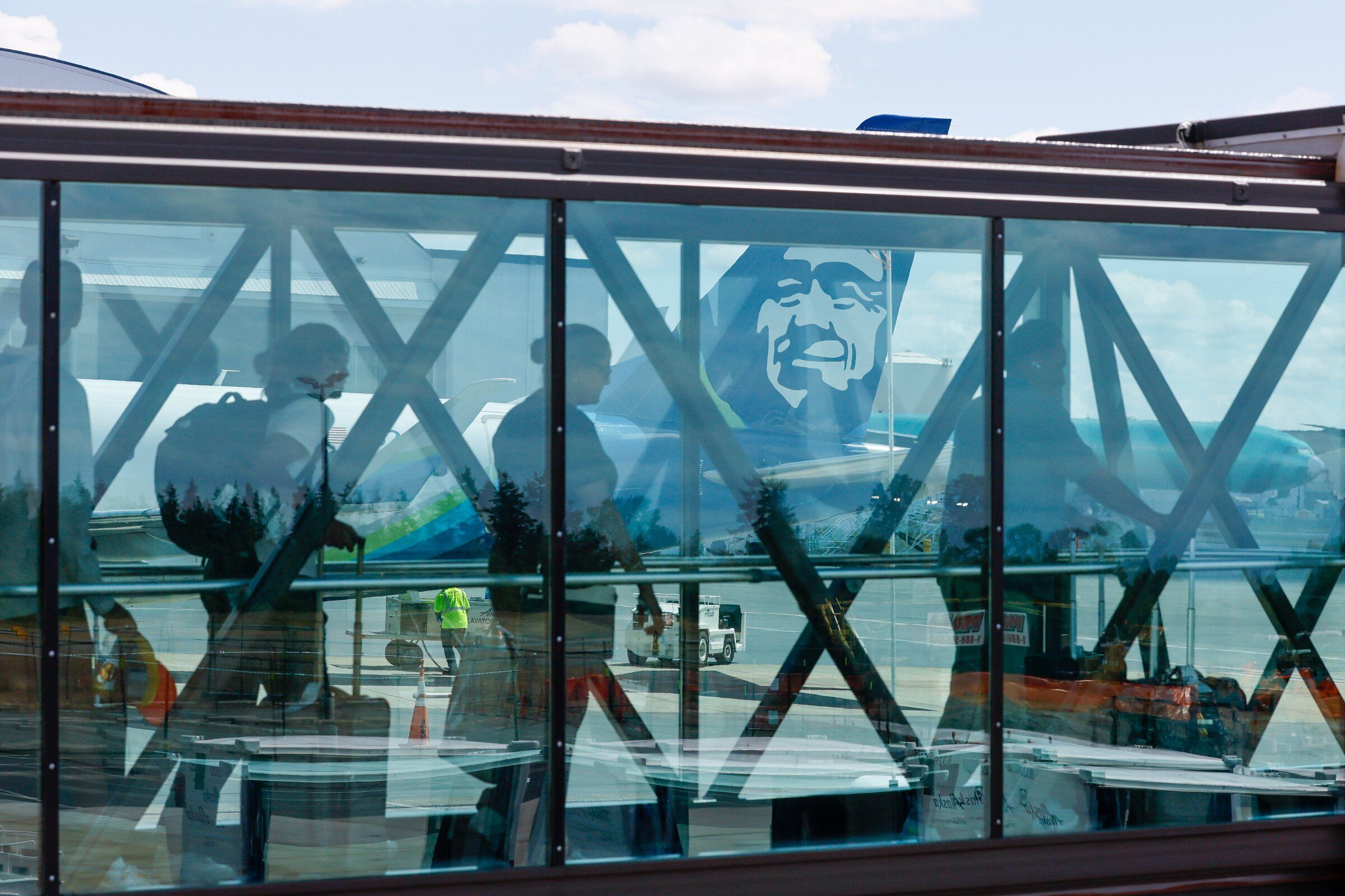 Passengers board an Alaska Airlines flight to San Francisco as another Alaska aircraft gets ready to depart to Anchorage at Paine Field Airport on July 25, 2023. (Jennifer Buchanan / The Seattle Times)