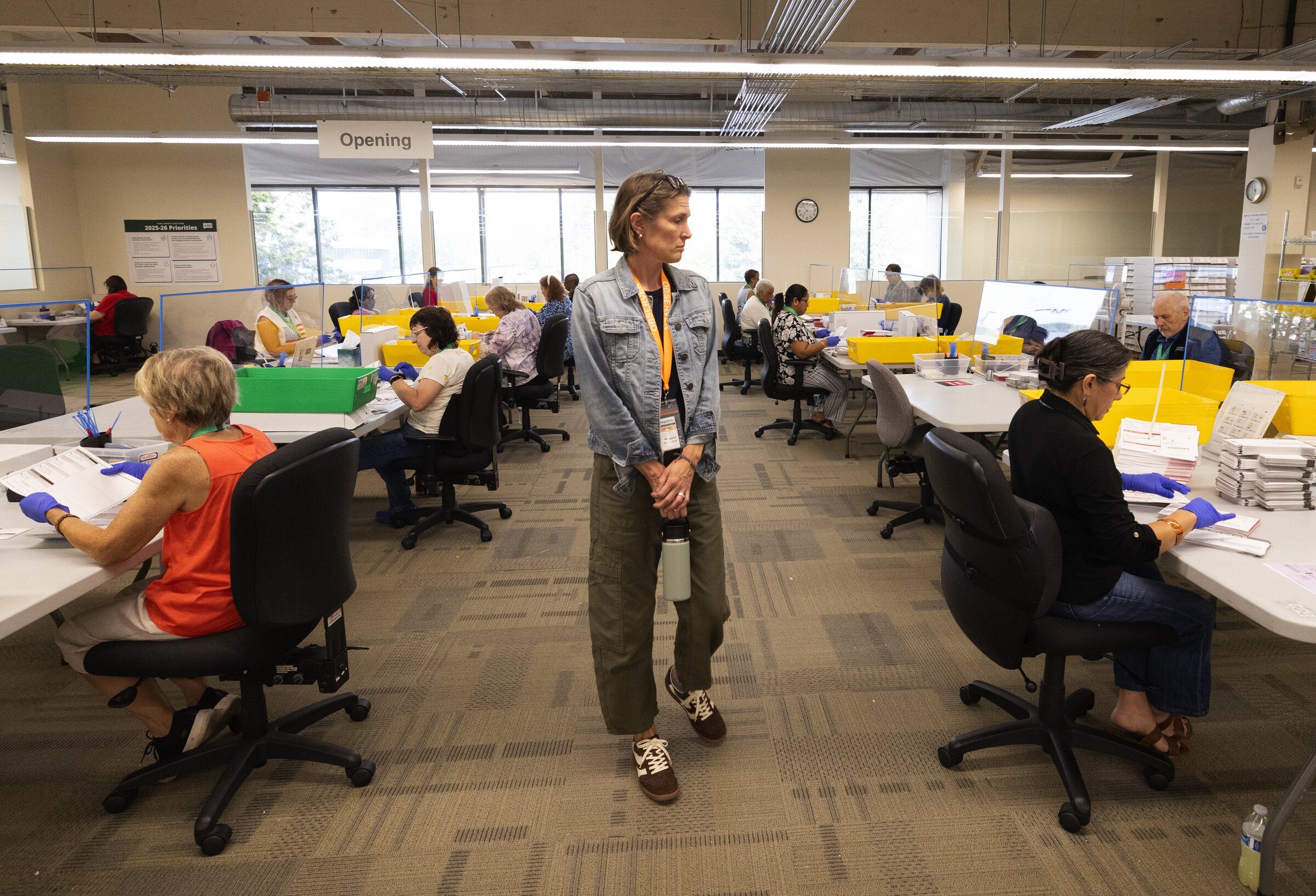 Margaret Butterworth, center, volunteers as a nonpartisan observer through the League of Women Voters as ballots are opened at King County Elections headquarters on Aug. 4, 2026, in Renton. (Ken Lambert / The Seattle Times)