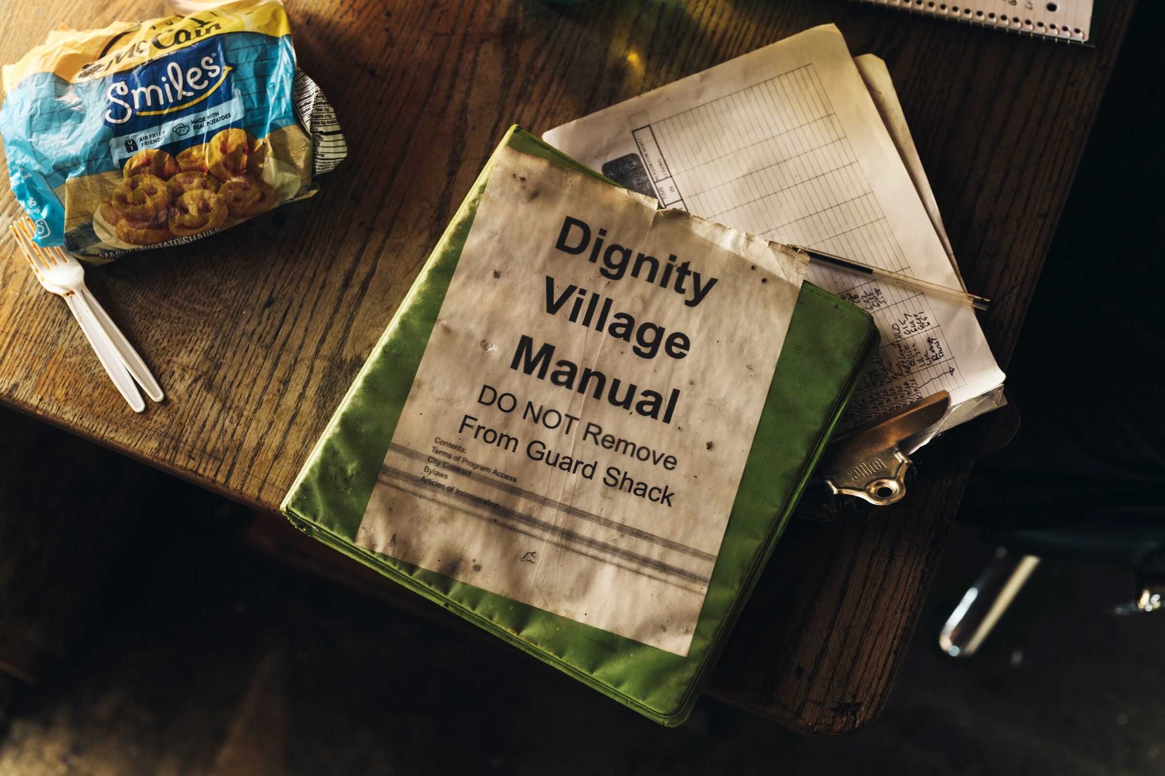 A rulebook in the guardhouse at Dignity Village, a community of about 60 people living in hand-built tiny homes on the site, Portland, Oregon, Aug. 19, 2026. All Dignity Village residents previously experienced homelessness and govern the community themselves—likely the only such community in the country that is not merely sanctioned by the city but also entirely self-funded and self-managed. (Ricardo Nagaoka / The New York Times)