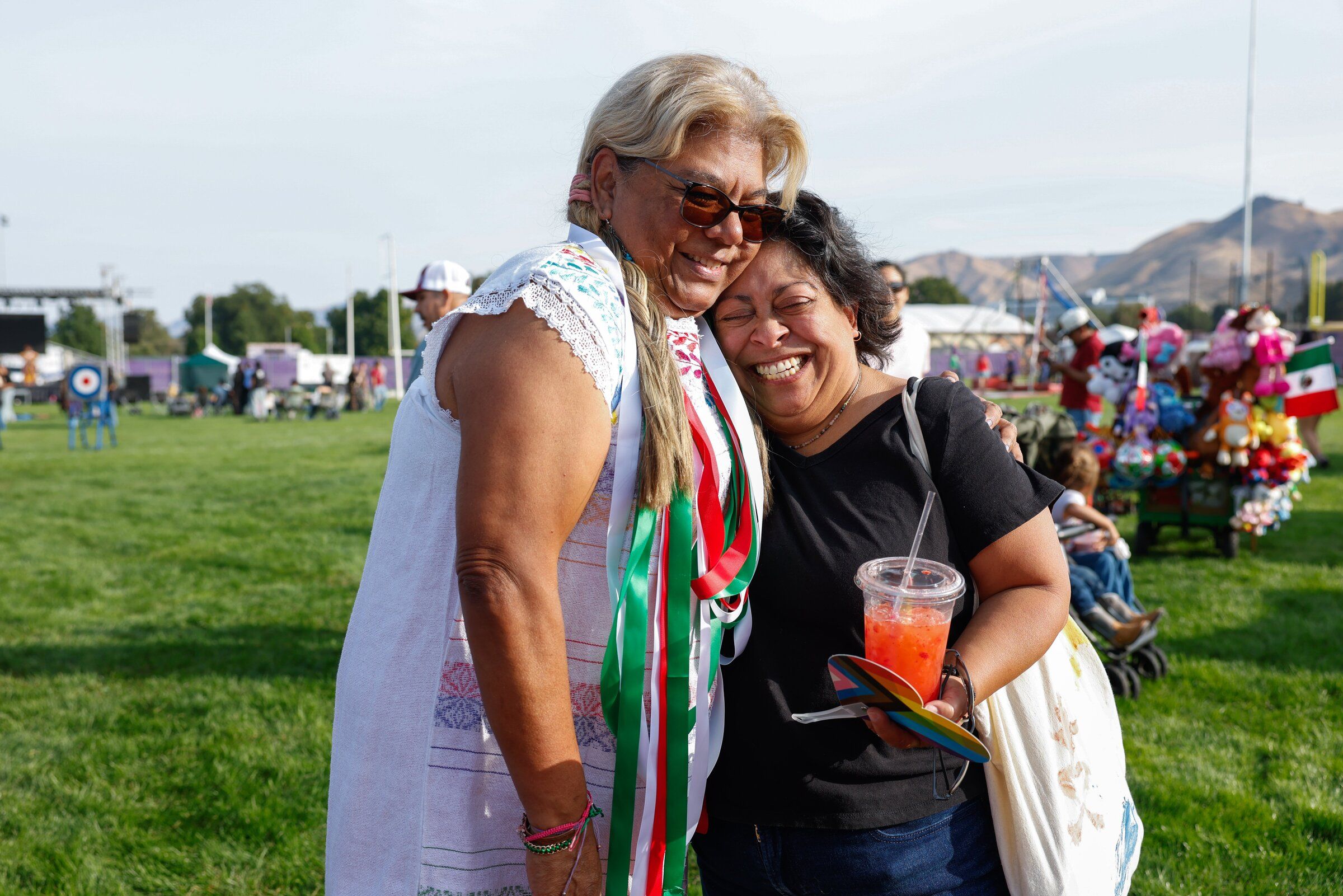 Gabriela Delgado, community engagement coordinator for Wenatchee for Immigrant Justice, hugs Stacey Willoughby at Fiestas Mexicanas, a celebration of Mexican Independence Day, in Wenatchee. (Andrew Burke-Stevenson / The Seattle Times)