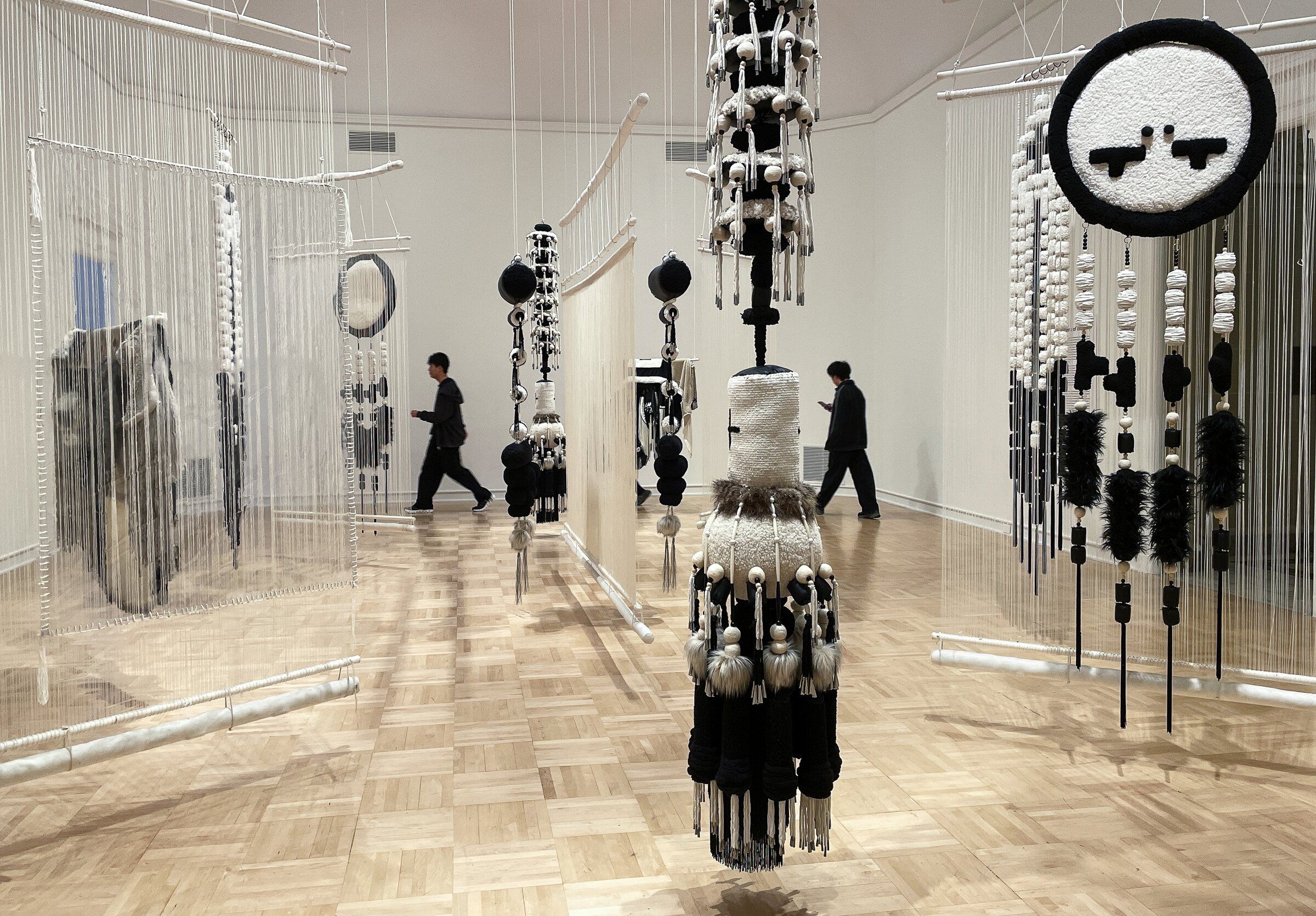 Visitors walk through “Totems of Memory,” part an exhibit by Eric-Paul Riege at the Henry Art Gallery on the University of Washington campus in Seattle on Saturday. The exhibition runs through Oct. 25. (Ken Lambert / The Seattle Times)