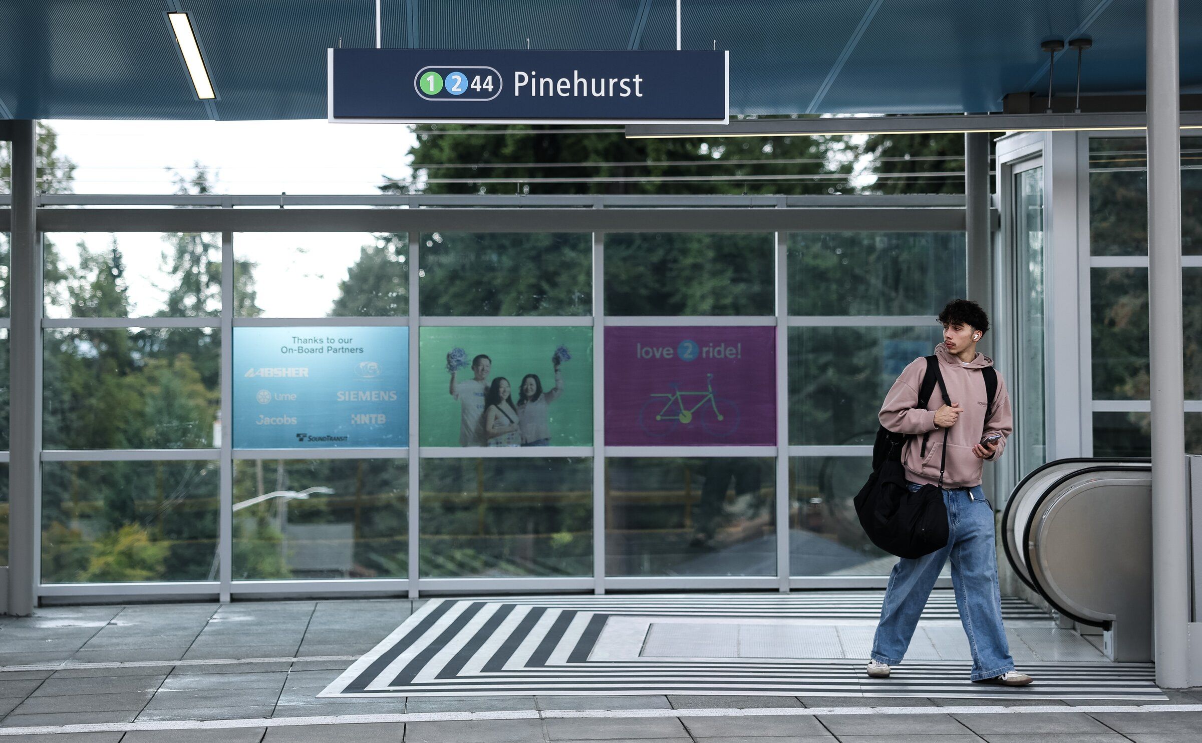 A light rail rider navigates the platform on the first day of operation Wednesday at the new Pinehurst Station in Seattle. (Nick Wagner / The Seattle Times)