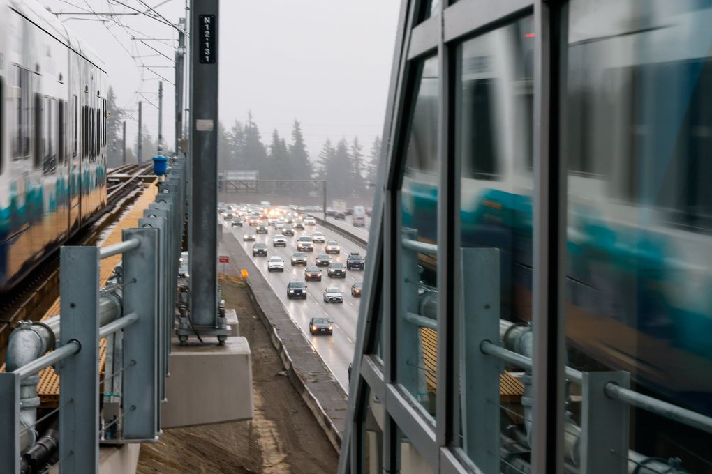 Glass reflects a southbound light rail train above Interstate 5 traffic at the new Pinehurst light rail station in Seattle. (Jennifer Buchanan / The Seattle Times)