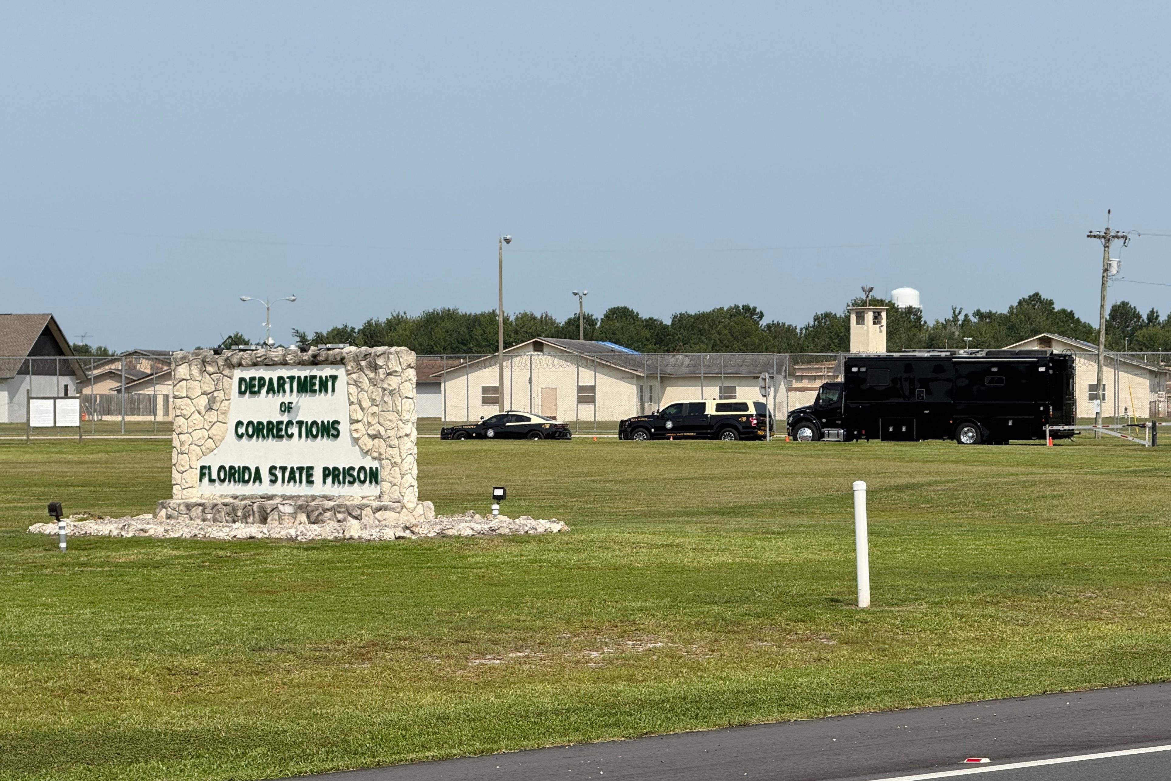 Law enforcement vehicles sit parked outside the Florida state prison in Starke, Fla., on July 28. (AP Photo/David Fischer, file)