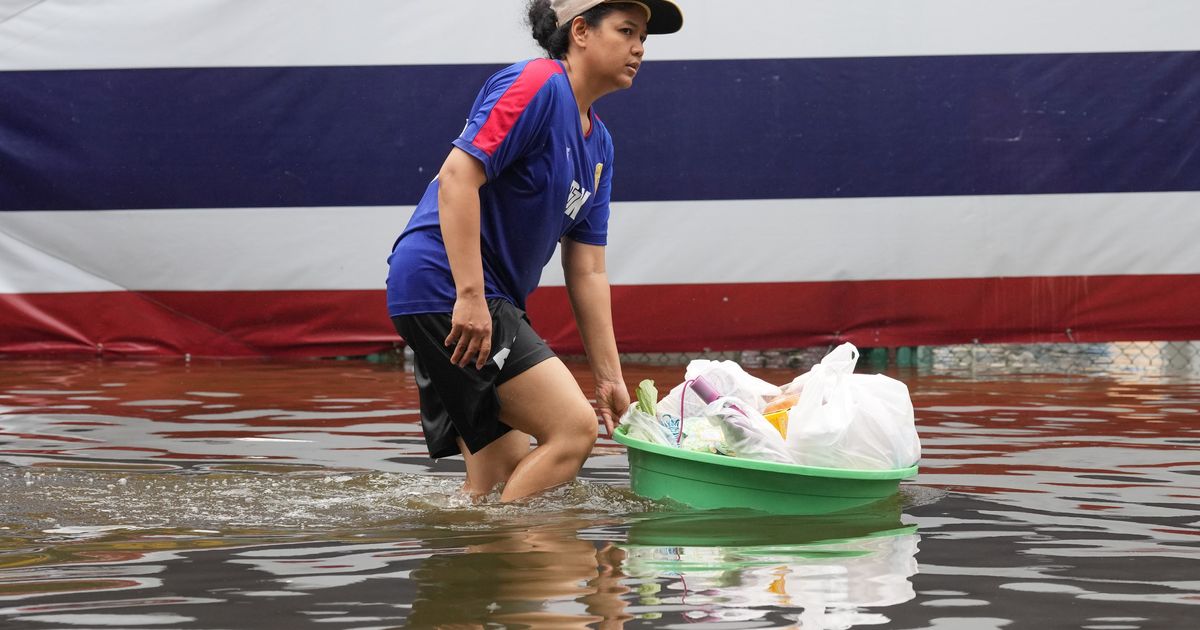 Rain eases in Bangkok but persistent flooding forces thousands to leave home