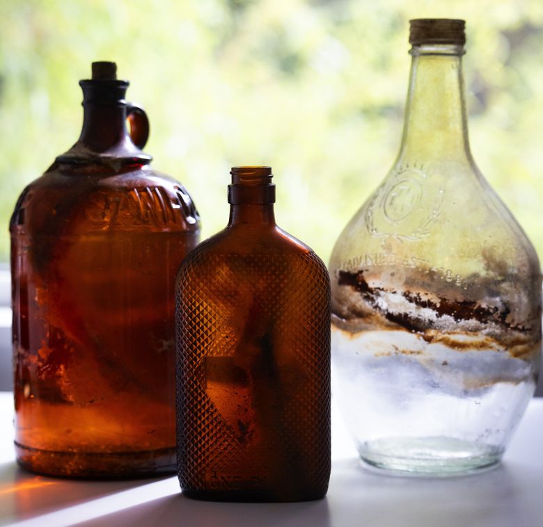 Vintage bottles are kept at the Keasler Cottage, which serves as the Floating Homes Association’s headquarters. Set on Lake Union in the Eastlake neighborhood, the organization is the keeper of Seattle’s floating homes history and hosts a tiny seasonal museum. The bottle to the right once held booze, which is not surprising since many speakeasies were set in houseboats during Prohibition. (Ken Lambert / The Seattle Times)