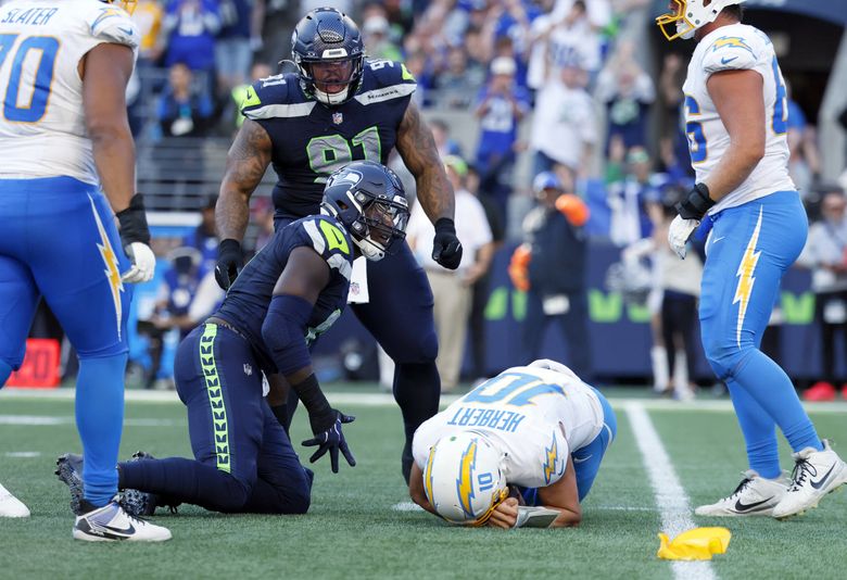 Seattle Seahawks defensive tackle Byron Murphy II (91) looks on as teammate DeMarcus Lawrence (0) commits a personal foul in the fourth quarter Sunday, Oct. 4, 2026 in Seattle. (Jennifer Buchanan / The Seattle Times)