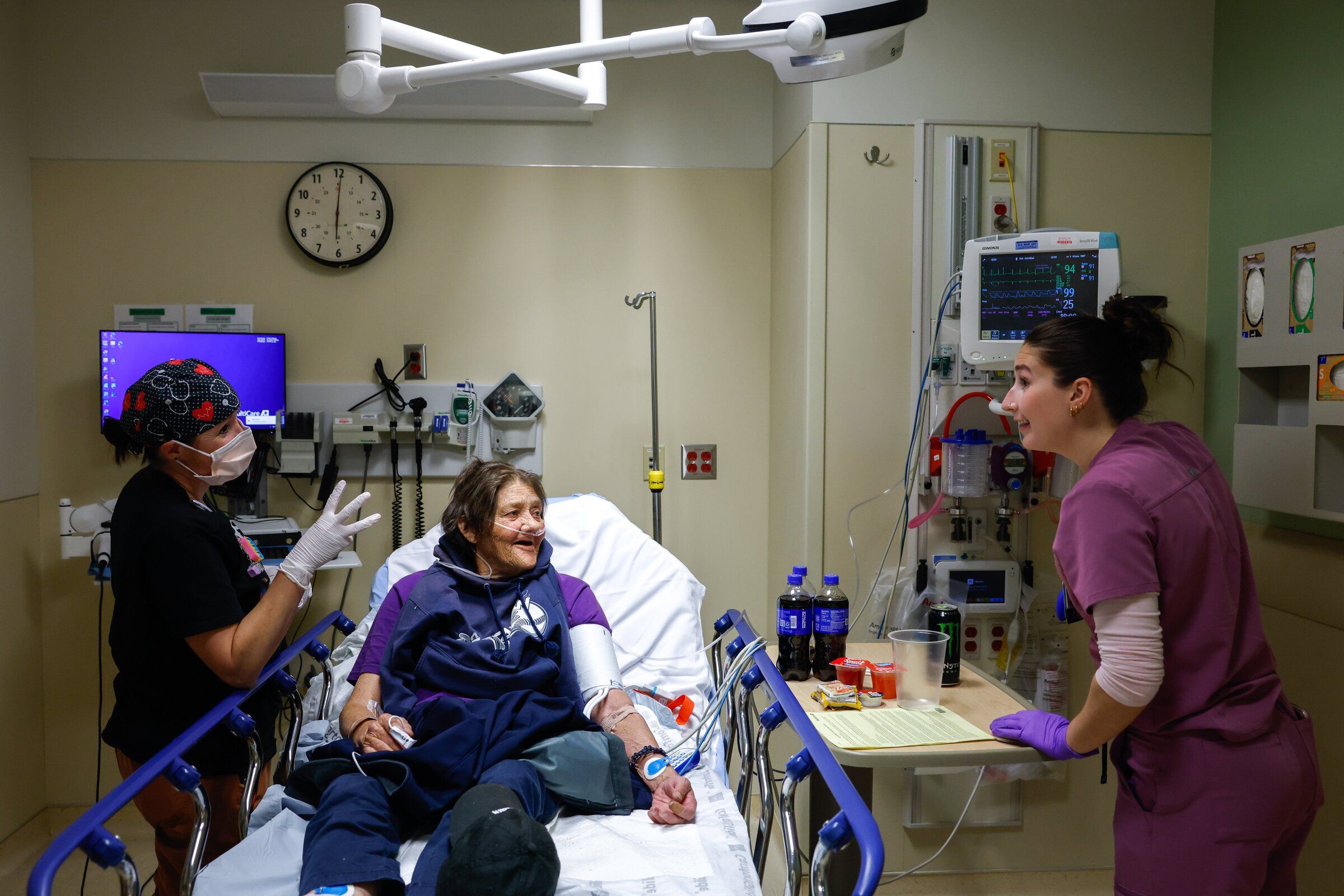 Registered nurse Christal Carlson, left, and certified nursing assistant Kendra Lewis, right, begin to examine patient Trish Horak in a room in Good Samaritan Hospital’s emergency department. (Andrew Burke-Stevenson / The Seattle Times)