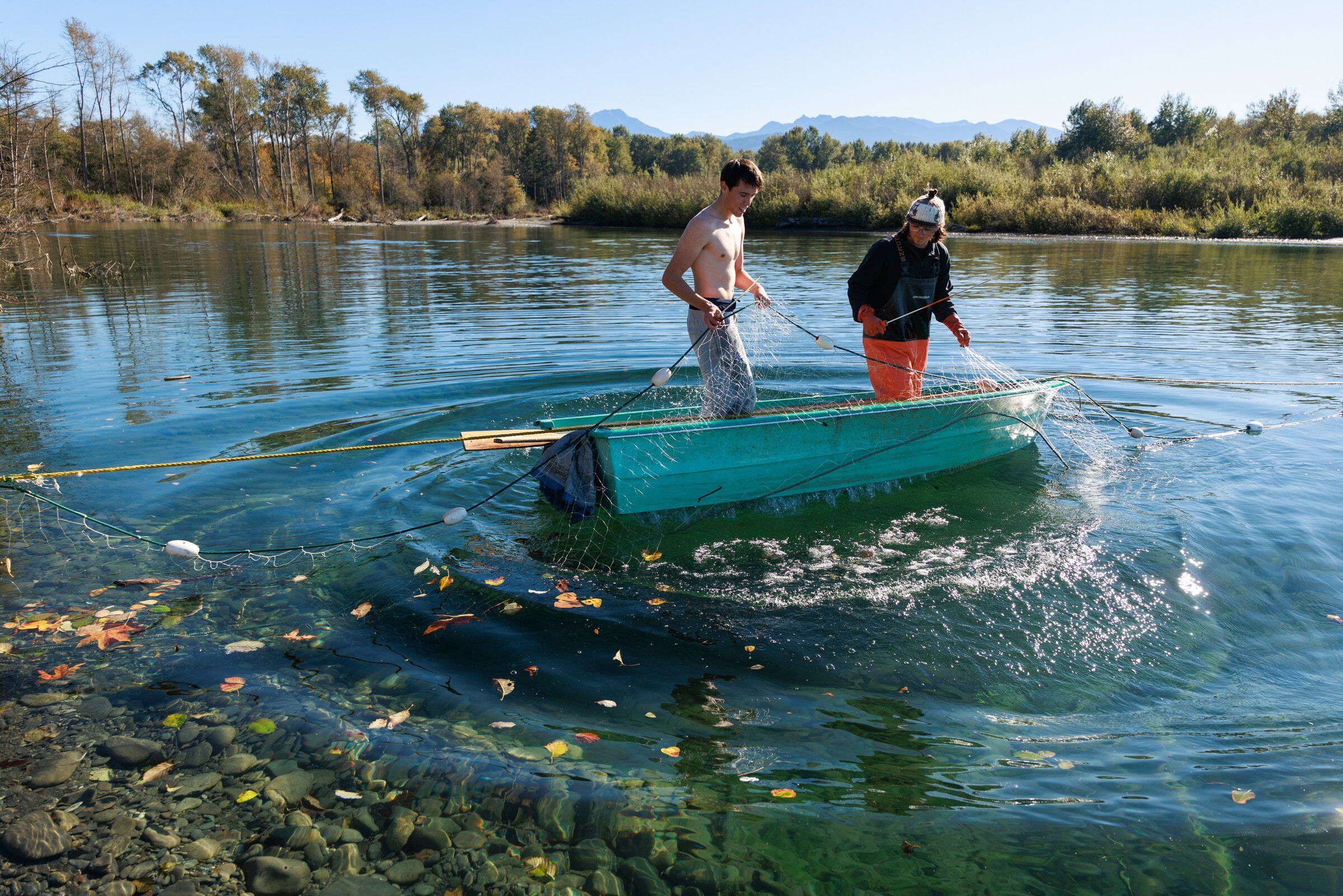 Joaquin Robidoux, left, and Niall Hepfer, members of the Lower Elwha Klallam Tribe, clean their nets while fishing for coho salmon at the mouth of the Elwha River on Wednesday. (Erika Schultz / The Seattle Times)