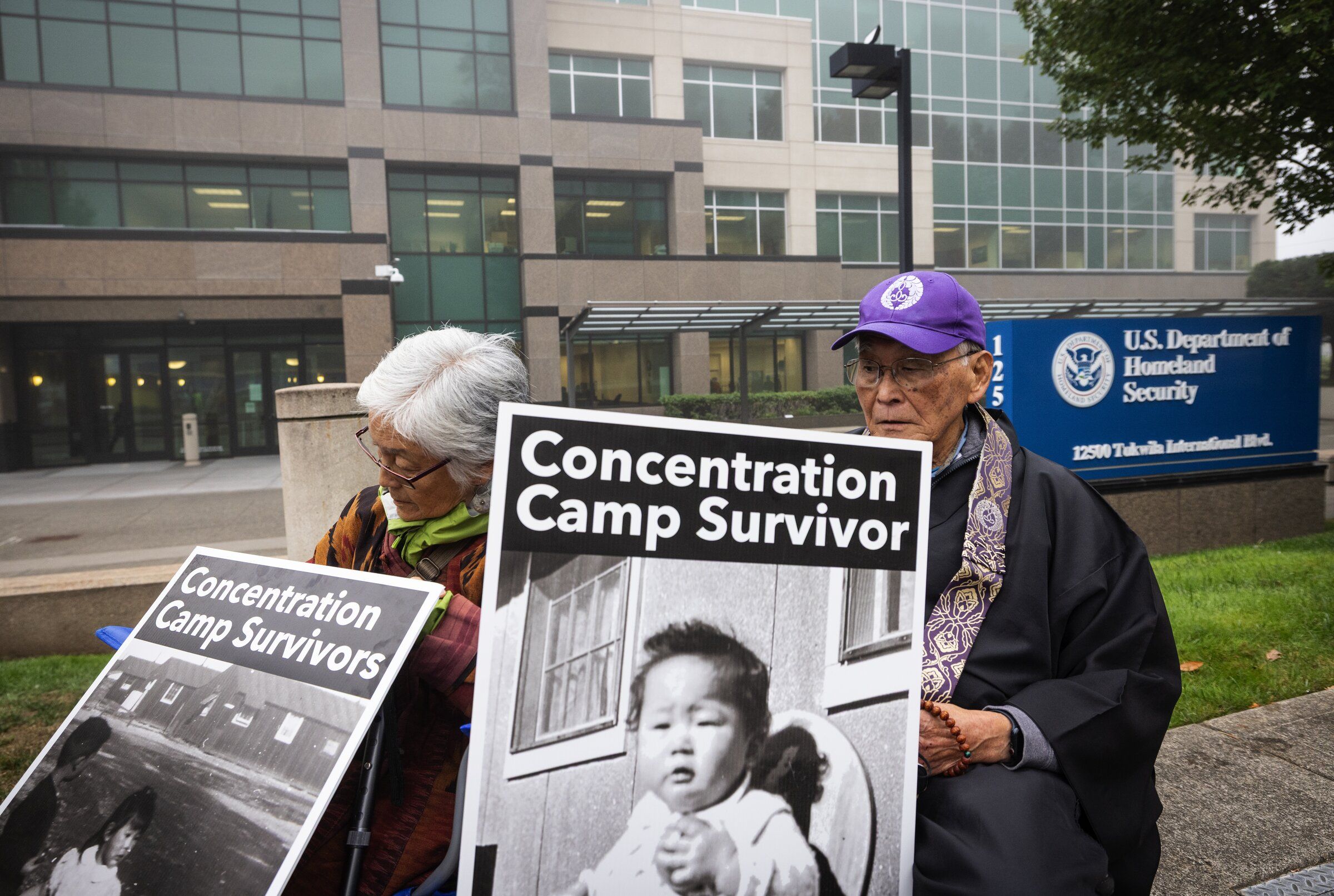 Satsuki Ina, left, and the Rev. Kenji Akahoshi, who were both held at incarceration camps during World War II as children, protest outside the U.S. Department of Homeland Security building in Tukwila on Thursday. The facility houses the U.S. Immigration and Customs Enforcement field office. (Ken Lambert / The Seattle Times)