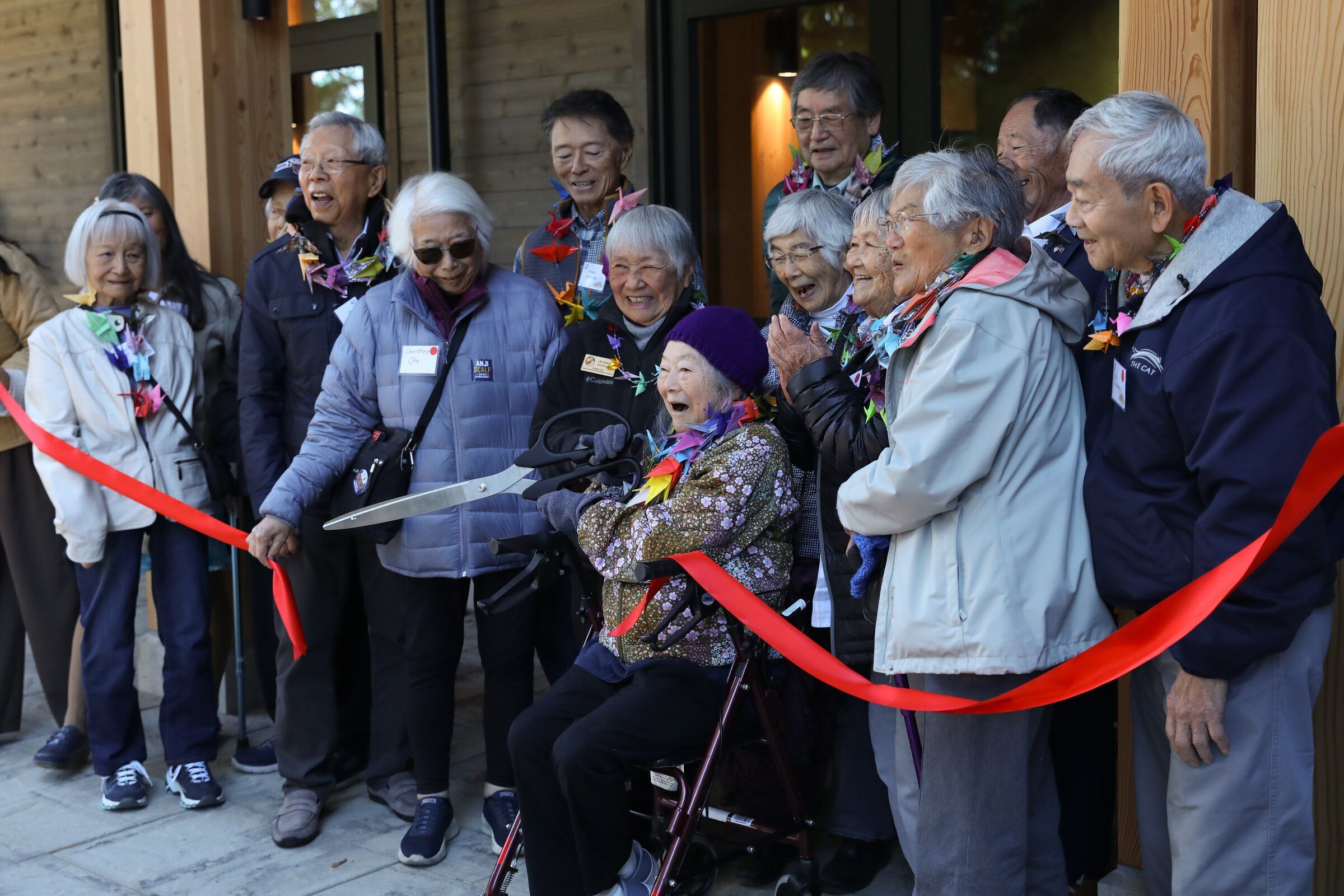 Hisako Matsudaira cuts the ribbon, opening the visitor center for the Japanese American Exclusion Memorial with other incarceration survivors on Bainbridge Island on Sunday. (Naomi Ishisaka / The Seattle Times)