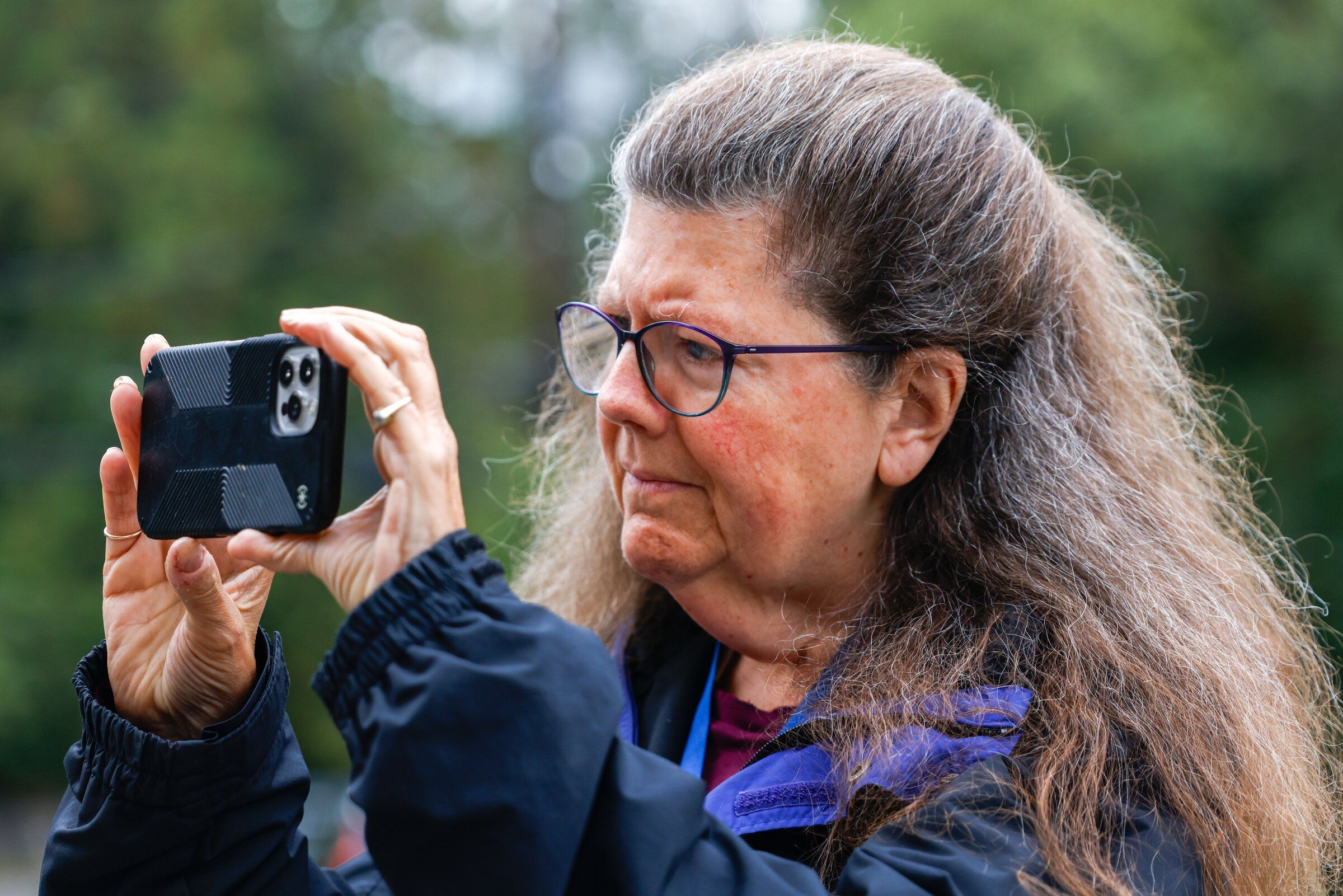 West Seattle Blog editor Tracy Record takes a picture at a recycling event at Fauntleroy Church in West Seattle on Oct. 3. (Andrew Burke-Stevenson / The Seattle Times)