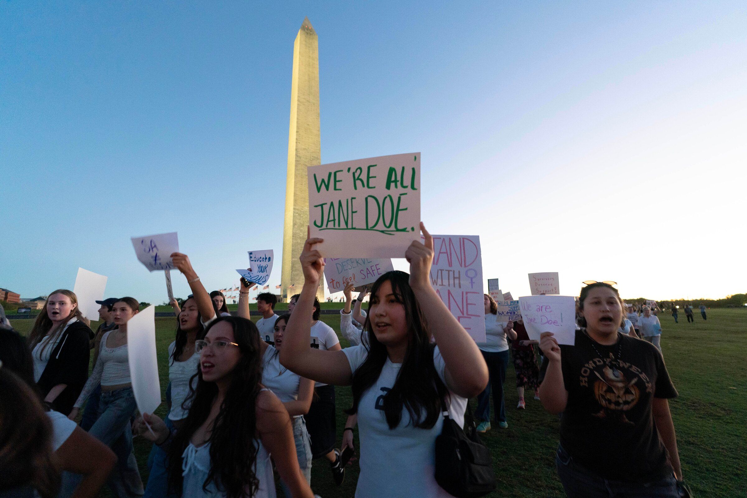 Demonstrators hold signs as they rally during a protest at the Washington Monument on Oct. 8 in Washington, D.C. (Jose Luis Magana / The Associated Press)