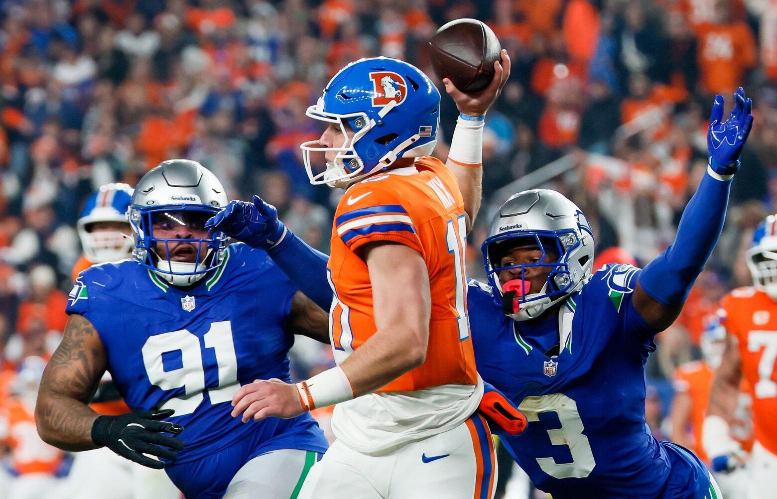 Seattle Seahawks defensive tackle Byron Murphy II, left, and safety Nick Emmanwori pressure Denver Broncos quarterback Bo Nix into an incompletion during the th