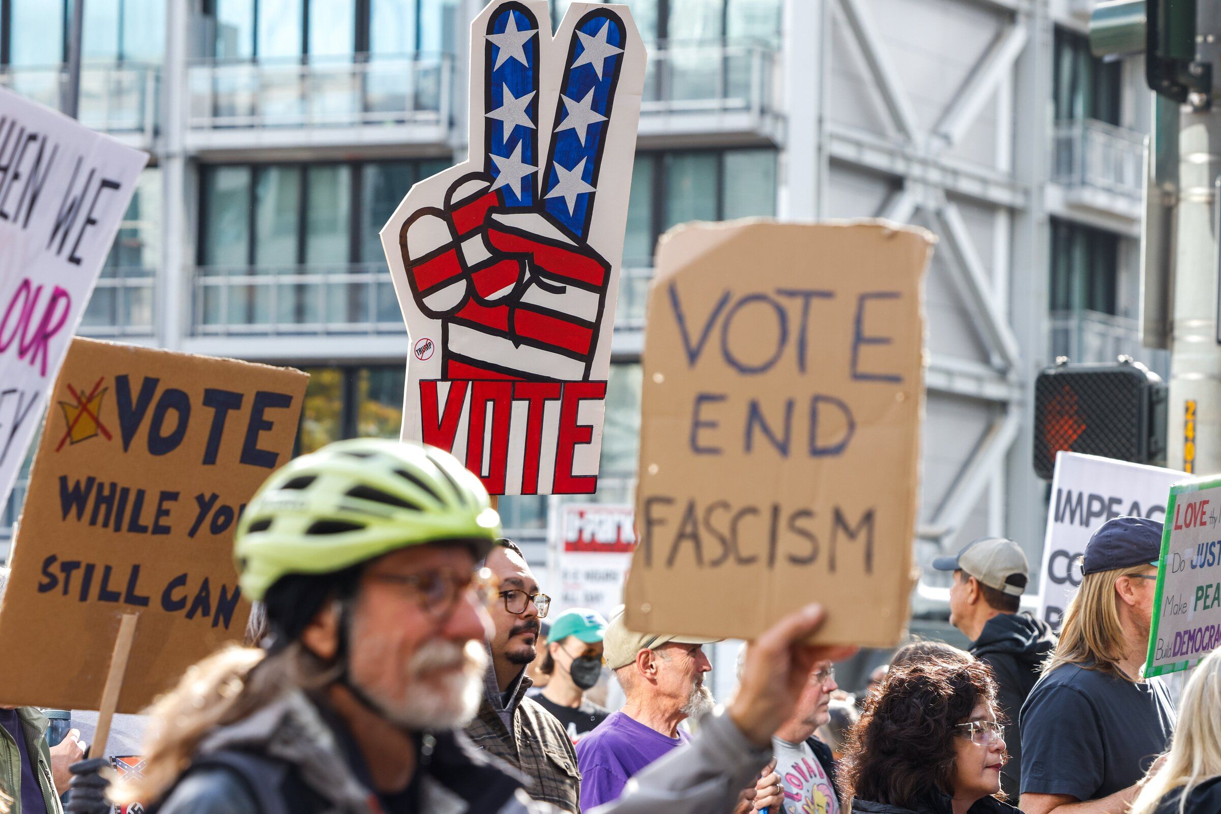 A protester holds a sign during the No Kings march through downtown Seattle on Saturday. (Andrew Burke-Stephenson / The Seattle Times)