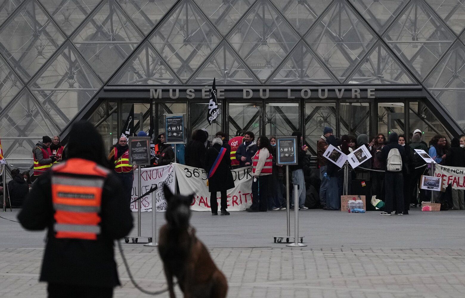 Workers block the entrance of the Louvre museum during a protests against rising living costs, in Paris, Monday, Oct. 19, 2026. (AP Photo/Christophe Ena) ENA104