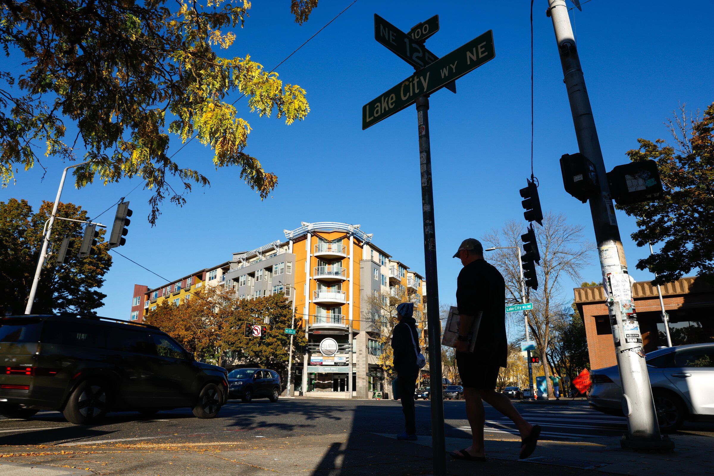 Pedestrians wait to cross at the busy intersection of Lake City Way Northeast and Northeast 125th Street in “downtown” Lake City. (Andrew Burke-Stevenson / The Seattle Times)