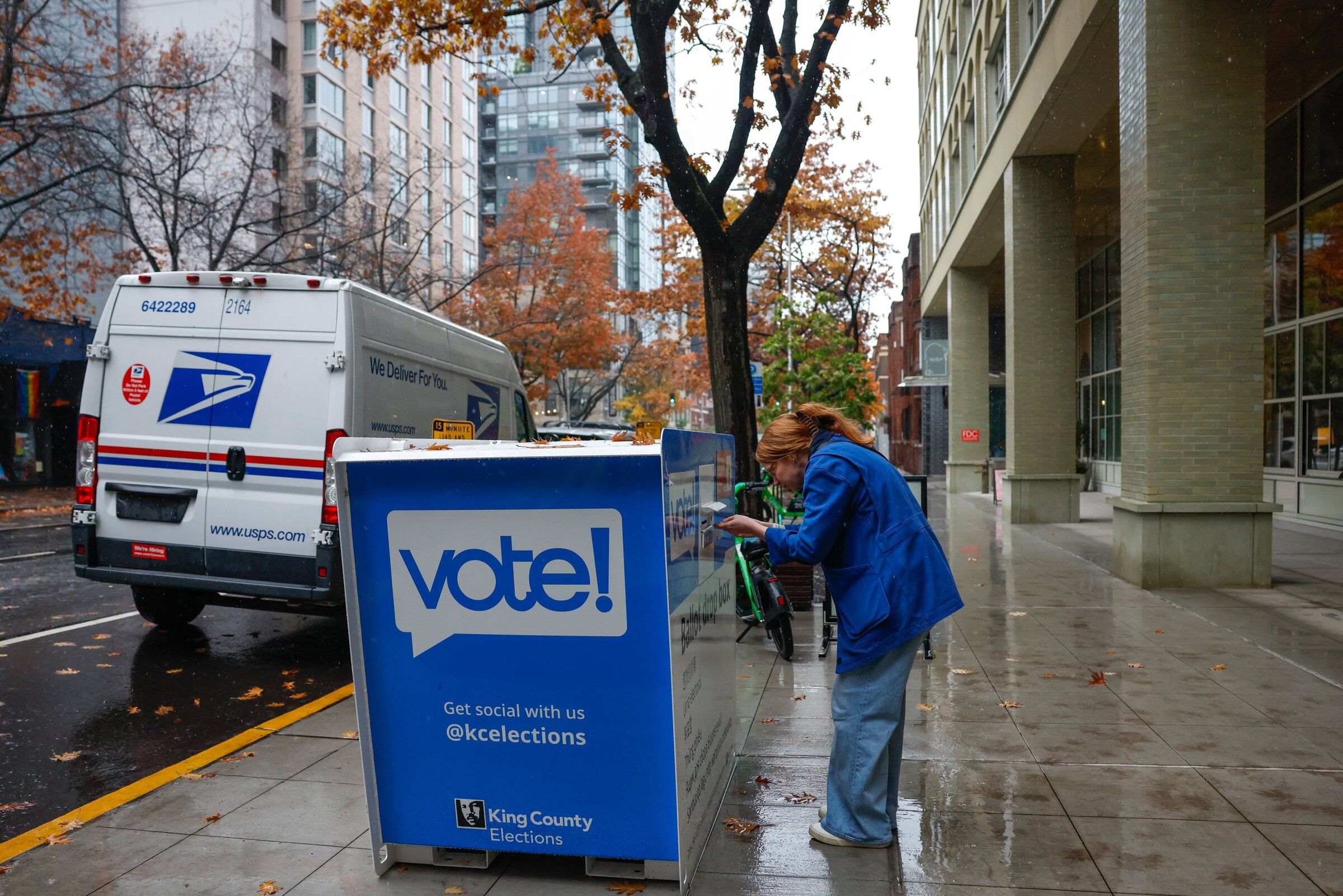 A person drops off a ballot at a King County ballot drop box in Belltown on Friday. (Andrew Burke-Stevenson / The Seattle Times)