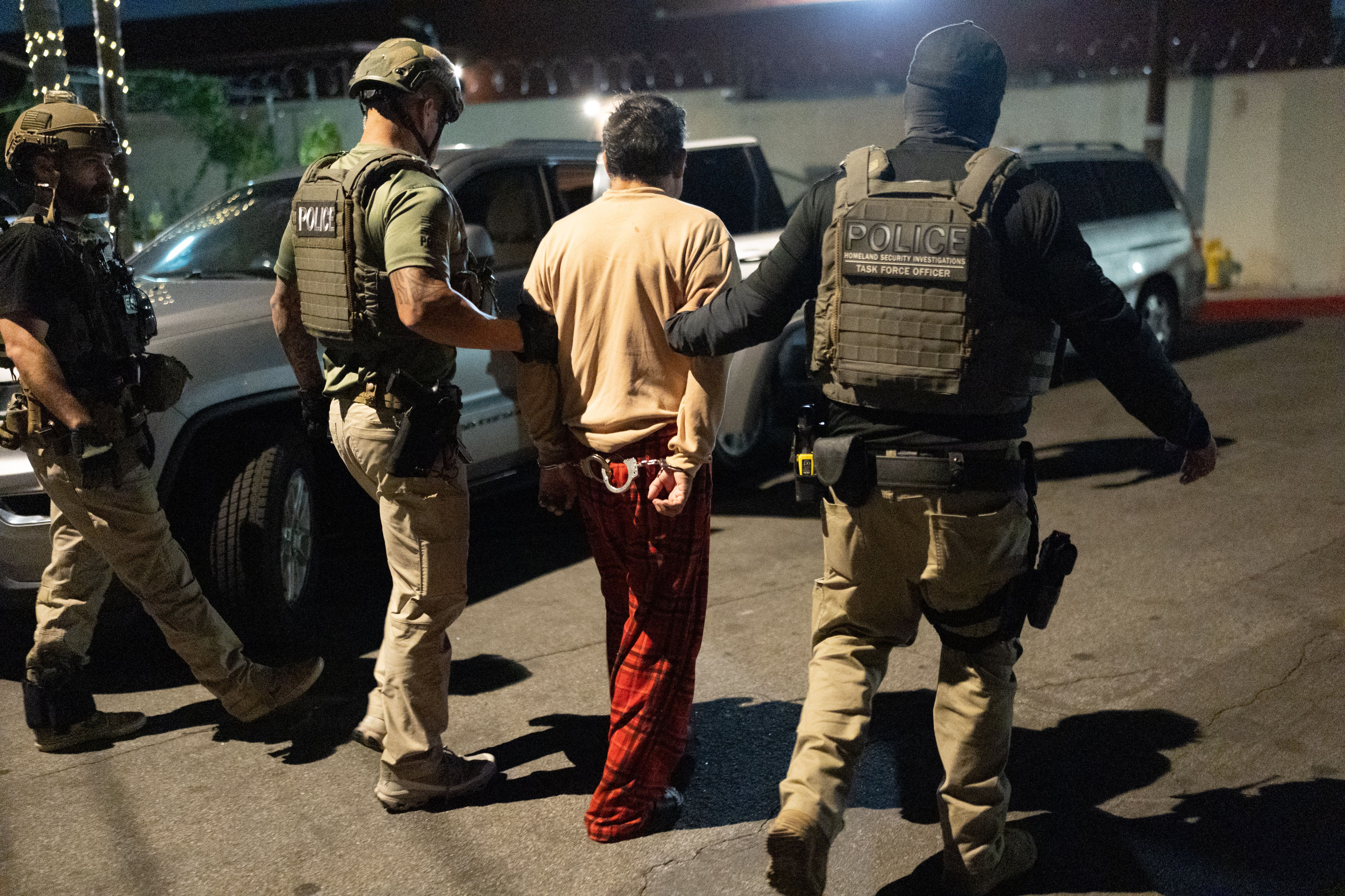 Homeland Security Investigations task force officers escort a suspect accused of illegally registering to vote during a federal operation in Commerce, Calif., Monday, Oct. 19, 2026. (AP Photo/Jae C. Hong)