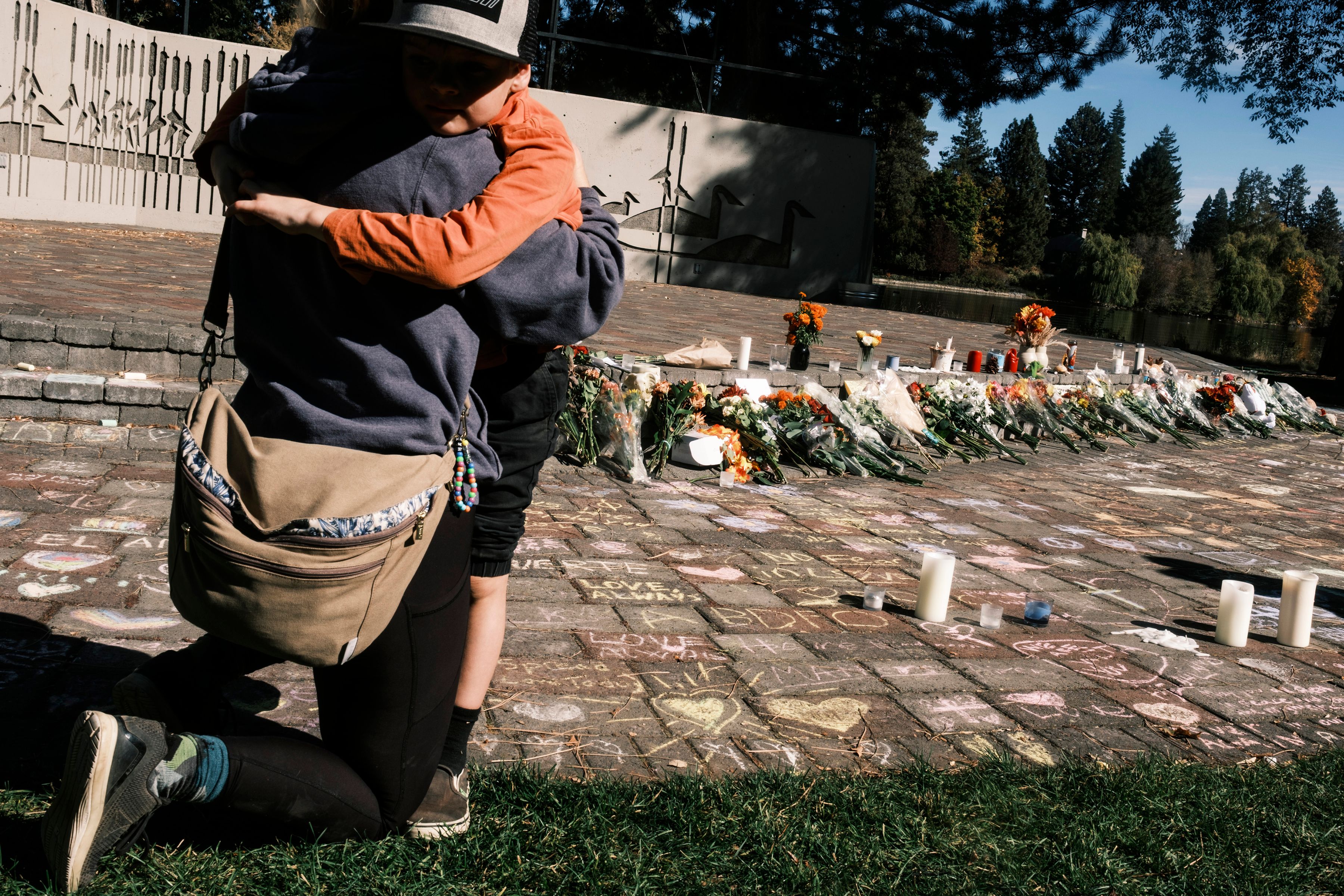 People embrace at Drake Park in Bend, Ore., on Friday, Oct. 16, 2026, the day after a gunman killed three children and a teacher at Silver Rail Elementary School. The teacher killed in the shooting, Megan Lambert, was a devoted early-career educator whose work at Silver Rail was her “dream job,” her family said Friday. (Jordan Gale/The New York Times)